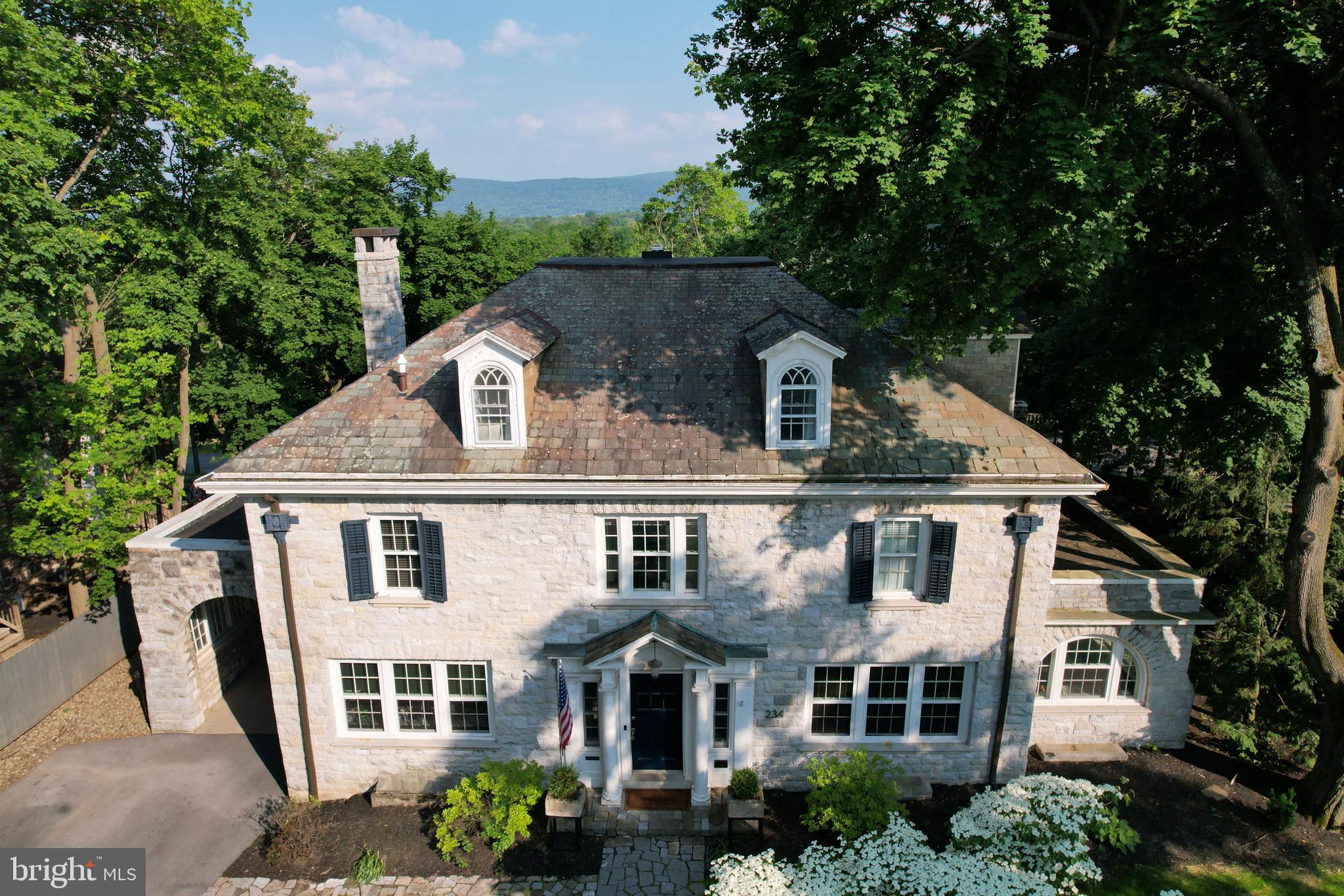 In the heart of downtown State College, this remarkable 1922 stone home—designed by noted architect A. Lawrence Kocher—offers 6,820 finished square feet of timeless elegance and modern functionality across four levels of the main house plus a fully renovated carriage house. Set on a spacious .40-acre lot, the main home features 5,406 sq ft above grade and 1,414 sq ft of beautifully finished lower-level space.  Additional information available on current rental permits and income as well potential ability to increase in occupancy for full B&B operation.  

A classic Georgian Four Square layout with a large entry foyer opening to all main rooms allowing for unparalleled entertaining. Thoughtful original details throughout the home include crown molding, real wood floors, French doors to most rooms on first floor, stairway railing and windows. Care has been taken by current owners to bring the home into a new modern era without eliminating the character and visual appeal of this period masterpiece.

Walk into the heated vestibule complete with coat closet with a window and custom door. Mail is delivered right into your mailbox that opens directly inside. Continue through the French door into the main foyer. You can see every room from this vantage point.

The fabulous kitchen was painstakingly designed to hide all your necessities yet leave them in easy reach. The quartzite countertop wraps around for ample workspace. Notice how the countertops were designed on a full flat level rather than lowering in front of the windows. A 5-burner gas cooktop with custom hood and backsplash. Built in dual ovens with convection and microwave. Built in Bosch coffee station.
Open living room, dining room and small office/nook complete the main floor. A beautiful living room gas fireplace is visible from the hallway. All the wood floors on this level have been recently refinished and the walls and trim painted.
Off to the far right there is an enclosed side porch with a fireplace that opens to the yard. Lined with windows it a bright sunny retreat. French doors to the living and dining area are original.

The staircase to the second floor features a large window that views mountains. A large landing foyer that opens to all rooms. 4 bedrooms, each with their own bath. The primary has a fireplace that is not in use. A walk-in closet can be entered from the bedroom and bathroom. Large bath has radiant heat floor, jetted tub, stall shower, double vanity, Toto toilet and heated towel rack. Connects to a bedroom that can be closed off or used as additional closet space.
Two additional bedrooms have captive full baths, one recently remodeled. The third floor has two cozy bedrooms with nooks and crannies and captive full bathrooms. A cedar closet is located here also.

The backyard is an oasis with several stone patios for small intimate gatherings or large-scale entertaining. A pond with running stream and fish sends soothing sound through the yard. This is a favorite feature of the current owners. There is an invisible fence for your pets too.

The main house exterior is all stone with a slate roof. Parking is ample with capacity for 13 cars on the property. There is also street parking nearby.

This is the only property in the Borough of State College zoned as a Bed and Breakfast. Current rental permits for Main house and Carriage House.
This one-of-a-kind property offers unmatched walkability to Penn State University, downtown shopping, restaurants, and nightlife—all while providing an expansive, private retreat in the center of it all.

Bedroom & Full Bathroom listed on Main Floor in Room Count fields represents the Carriage House bedroom and bathroom.   More details available to agents in documents tab.

Password for 3D tours is limestone all lower case.