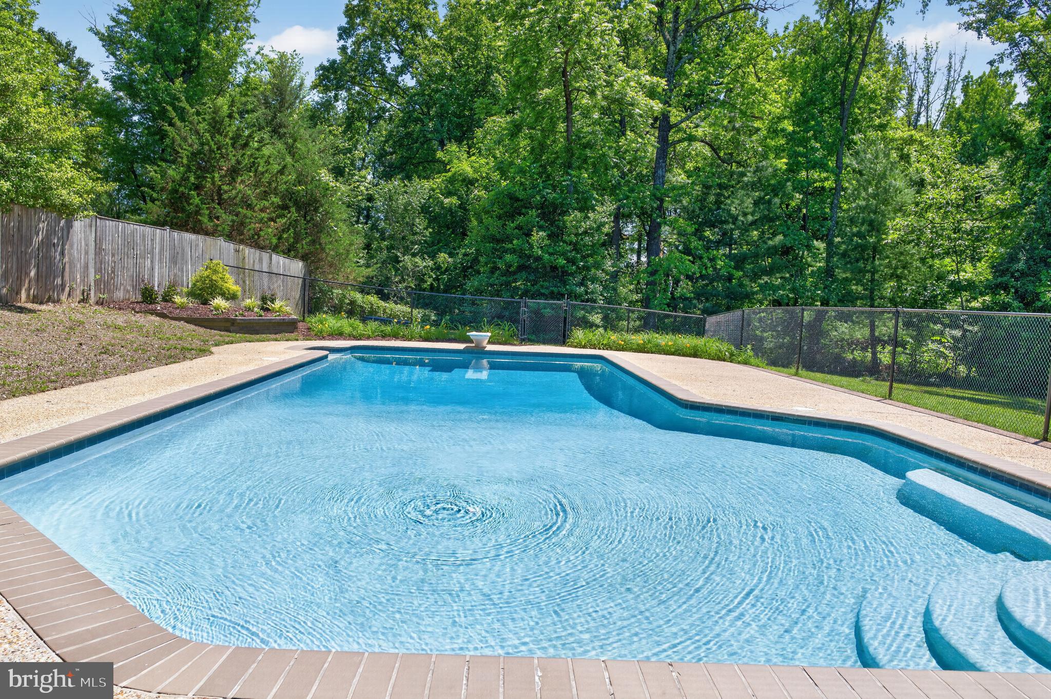 Welcome to 6727 Newington Road, an outstanding 2-level rambler with a large pool, 2 fireplaces, a screened porch and a slate patio sited on a rare over-an-acre private lot in Lorton’s desirable Hunter Estates. The long driveway has plenty of space to park your RV or all your guest’s cars at your next summer pool party. The pool patio has plenty of room for loungers and pool service for the season plus winter closing is included. This home is 4-sides brick with some siding in front. A winding slate walk and steps lead to the entrance. Once inside, your eyes are drawn to the beautiful hardwood floors which flow from the foyer through the living and dining rooms, down the hall and in three bedrooms. The entire residence has been freshly painted in neutral tones. A large picture window floods the living room with light and the wood-burning fireplace can easily be converted to gas. Both the living and dining rooms have crown molding and the dining room steps out to the lovely screened porch. In the kitchen, the GE stove and microwave are new and the Bosch dishwasher has been recently replaced as well. The window planter box gives your green thumb a cheery spot to show off! There’s also a tile backsplash and double-sink. A full staircase leads up to the enormous floored attic - perfect for all your storage needs. All three upper bedrooms have modern ceiling fans. On the great walk-out lower level, you first encounter the spacious rec room with its gas fireplace and floor-to-ceiling brick surround. French doors lead to the 4th bedroom/bonus room with recessed lighting and a wide window overlooking the huge slate patio with stacked-stone retaining walls and planter beds. There’s a full bath with a stylish vanity, tile floor and a large nook for products in the shower. You’ll also find another bonus room and the big laundry/storage room which walks out to the side yard and patio. There is a battery back-up on the sump pump. The backyard has lots of tall mature trees, a shed, wood storage, a huge playset for kids and a sandbox with benches. This fine home has an envied location, just down the road from Wegman’s and Fort Belvoir, close to Metro, all commuter routes, two town centers and a quick hop to Old Town Alexandria! Note: Home is on septic and perks for 3 bedrooms. Fourth bedroom in basement has multiple windows and easy egress but is not to-code. New Roof 2017, New HVAC 2020