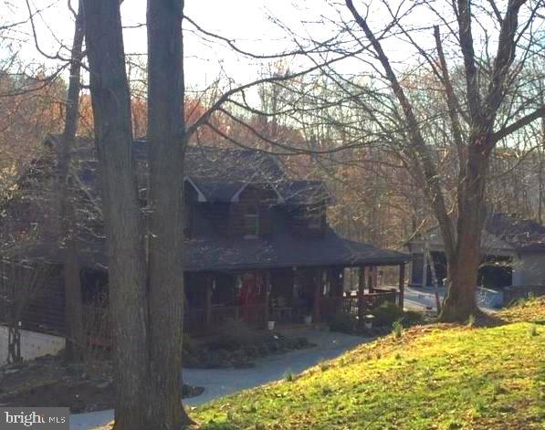 Looking for privacy??  This is it!  This log home is nestled on 3 very private, mostly wooded acres.  You will love the spacious rooms with hardwood floors.  The huge 1st floor Master Suite has walk in closets, a gas fireplace, and claw foot tub.  You will love the vaulted 2 story ceiling in the great/living room with a second fireplace complete with a pellet stove insert and a second floor gallery. On the second floor you will find two large bedrooms with walk in closets, extra storage and pine flooring. There is also a finished lower level with a spacious family room with built-ins, a kitchenette, a second laundry room, bonus room, workshop and a third full bath.  This private oasis borders the Heritage rail trail.  Step out onto your maintenance free deck with your morning coffee...you will be overlooking the wooded area... you just might see a small herd of deer or other wildlife.   There is lots of outdoor living space with the wrap around side decks and the oversized rear deck. Just minutes to all conveniences such as dining, fitness and shopping and I-83.    It's very pretty up here on the hill.... come check it out!
