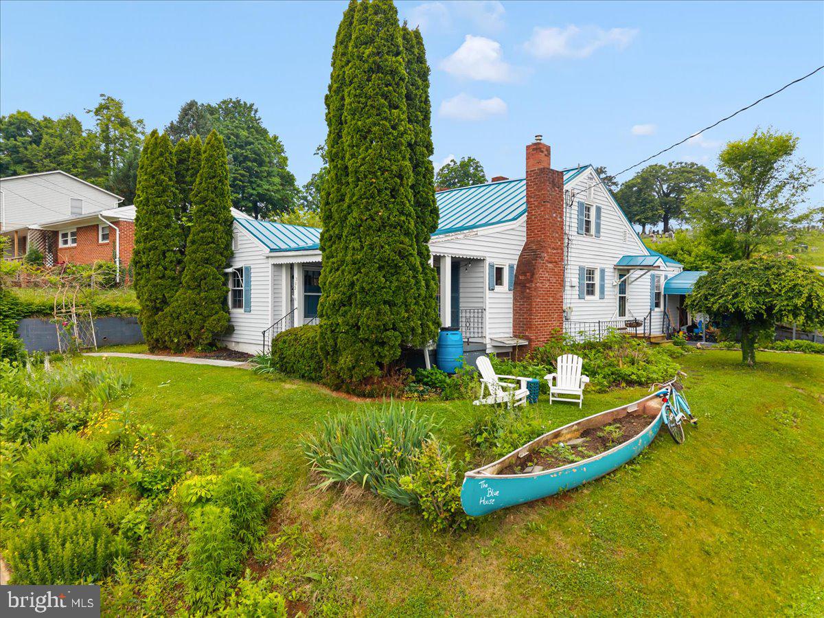 Tucked into a quiet corner of Front Royal, this charming home blends cottage character with everyday functionality. Located near the Shenandoah River, Skyline Drive, and downtown Main Street. The home features a metal roof, covered front and back porches, carport, newer windows, and a spacious yard with mature evergreens and a welcoming front porch setting. Inside, the main level offers a comfortable layout with a country kitchen, dining room, living room, and two bedrooms with en-suite baths, while the upper level adds two additional spacious bedrooms. Original maple cabinetry, Corian counters, hardwood floors, original woodwork, and ceramic bathroom flooring give the home warmth and character throughout. The dining room fireplace with wood-burning stove adds a cozy focal point for gatherings. The wood stove is not currently connected. A great fit for buyers looking for charm, outdoor space, and easy access to Front Royal’s trails, river, downtown shops, and mountain-town lifestyle.