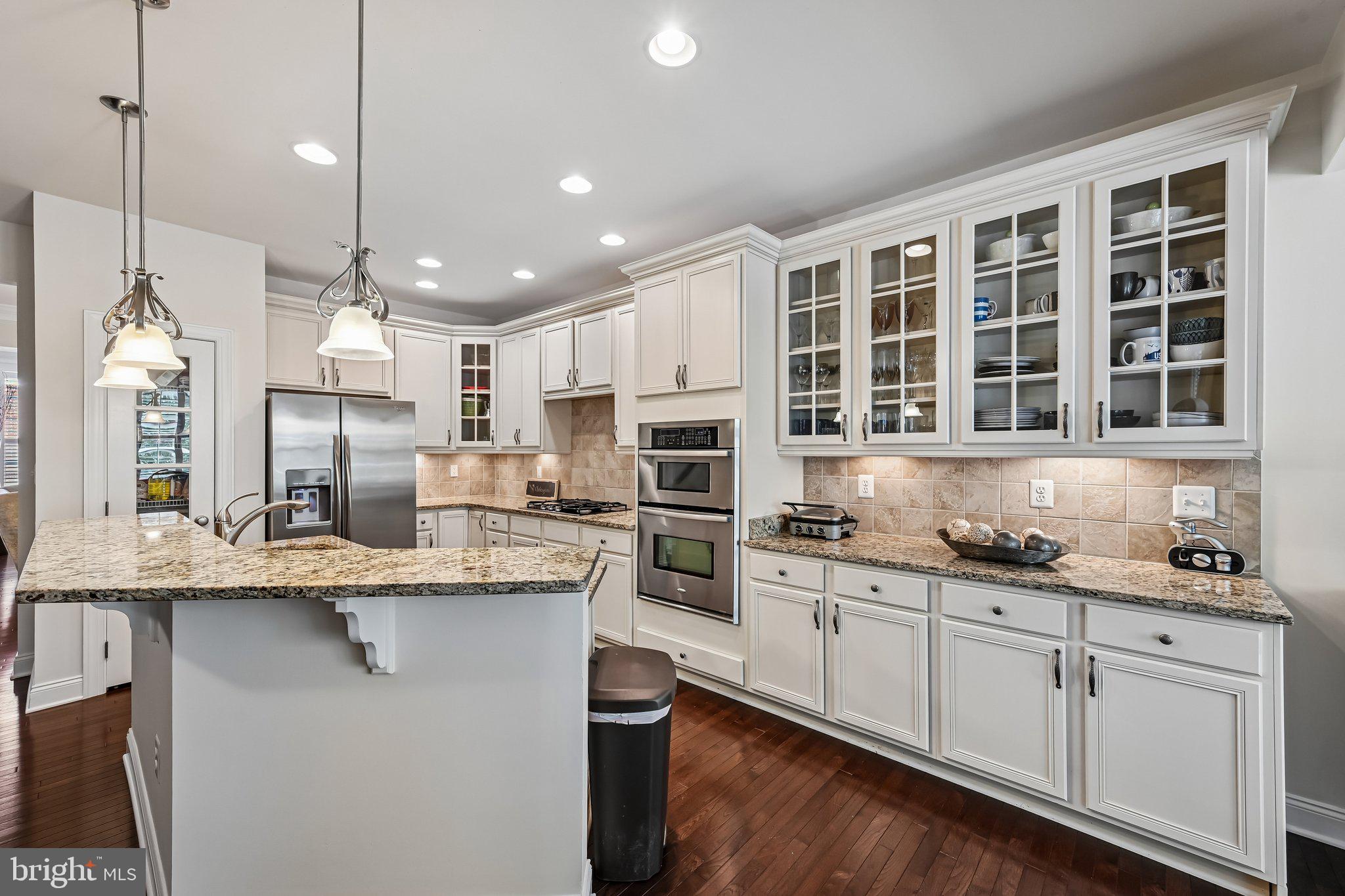 Owner says to get it sold and reduced the price accordingly. Welcome to this beautifully designed four-level brick-front townhome offering over 2700 square feet of finished living space over four levels, a two-car garage, and a layout that blends everyday comfort with elevated design. Recently refreshed with fresh interior paint and professionally cleaned carpets, the home shows bright, clean, and move-in ready.

The main level features gleaming hardwood floors, 9-foot ceilings, and an open, flowing layout ideal for both daily living and entertaining. A formal living and dining room lead into a gourmet kitchen complete with granite countertops, stainless steel appliances, gas cooking, a breakfast bar, and a sun-filled morning room. Just off the kitchen, the family room with a gas fireplace creates a warm, inviting gathering space, with direct access to the rear deck and lower patio overlooking trees and open common area.

Upstairs, the spacious primary suite offers a true retreat, featuring a tray ceiling, private sitting room with vaulted ceiling, walk-in closet, and a luxury bath with soaking tub, separate shower, and double vanity. Two additional bedrooms, a full hall bath, and convenient upper-level laundry complete this level.

The top floor loft is a standout feature, offering incredible flexibility as a game room, theater space, or additional living area, enhanced by vaulted ceilings and multiple skylights that bring in abundant natural light.

The fully finished lower level provides even more versatility, with space for a fourth bedroom, recreation area, office, or guest suite, along with a full bath and interior access to the oversized two-car garage.

Outdoor living is just as appealing, with a rear deck and patio backing to trees and open space, creating a more private and peaceful setting.

Located in one of Hanover’s most convenient communities, residents enjoy resort-style amenities including a clubhouse, pool, fitness center, walking trails, and more, all within walking distance to shopping, dining, and everyday conveniences. Commuters will appreciate easy access to Fort Meade, BWI Airport, Arundel Mills, and major routes including 295, 95, and 100.