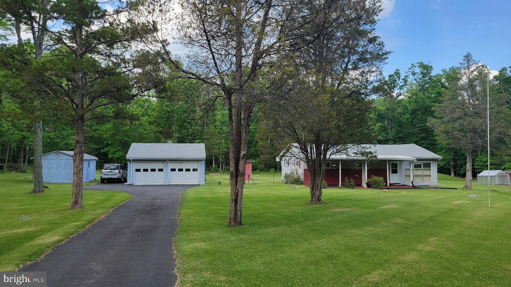 Country Charm Meets Opportunity on Nearly 2 Acres........Tucked away in the peaceful countryside of Spring Mount, this inviting ranch home offers the privacy and tranquility so many buyers are searching for. Set well back from the road on approximately two scenic acres, the property provides the perfect backdrop for gardening, outdoor entertaining, or simply enjoying the sights and sounds of nature.

Filled with natural light, the home's many windows create a bright, cheerful atmosphere while framing beautiful views of the surrounding landscape. An expansive 30' x 8' covered front porch welcomes family and friends, while the 10' x 7' screened porch offers the perfect spot to enjoy morning coffee or unwind on summer evenings without the bugs.

This home presents an excellent opportunity to add your personal style while benefiting from several important improvements already in place, including public sewer service, a newer roof, replacement windows, pull down attic with thermostatically controlled attic fan, and low-maintenance vinyl siding. A full-length crawl space with a sump pump provides convenient access beneath the home.

Designed for year-round comfort, the home features oil-fired hot water baseboard heat, known for its steady warmth, along with leased propane service for the kitchen range and dryer. Two wall air conditioning units and three ceiling fans help keep the interior comfortable throughout the warmer months. A water softener is also available for future use.  As an extra buyer comfort, a one year Americas Preferred  Home Warranty is included with the purchase.

Outdoor enthusiasts and hobbyists will appreciate the property's impressive collection of outbuildings, including a 20' x 10' workshop/outbuilding, an additional tool shed, and a detached two-car garage with automatic door openers. The garage also houses the oil tank and offers direct access to a breezy 18' x 11' rear covered porch overlooking a peaceful tree line and wooded backdrop.

 Whether you're looking for your first home, a weekend retreat, or a property with room to grow, 245 Fulmer Road offers the rare combination of rural charm, practical updates, and endless possibilities—all within easy reach of parks, and the conveniences of the nearby quaint Skippack Village, Spring Mount ski area, the Perkiomen trail system, Philadelphia Premium Outlets and major highways like Route 422 the Pa. turnpike and Route 476. Hurry out and make this home yours. It only awaits your personal touches.