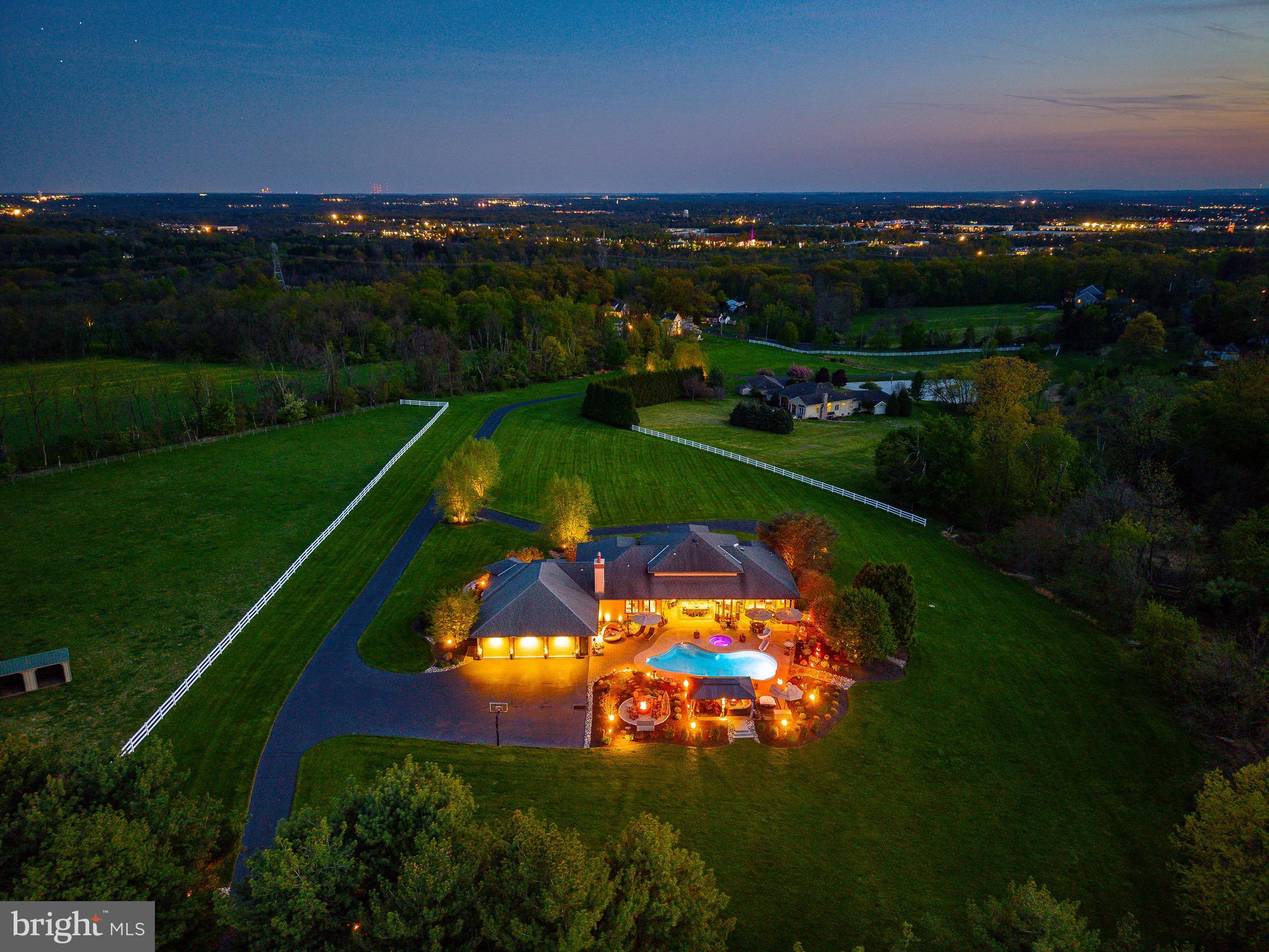 This exceptionally luxury residence offers over 5400 total square feet of living space, which includes over 3600 beautifully finished above- grade living space and an additional 1800 plus square feet in the fully finished lower level, creating an extraordinary amount of versatile living and entertaining space,  perfect for recreation, wellness, guests, or a private retreat. The home is set against the backdrop of sweeping panoramic vistas, this extraordinary 11-acre plus gated estate perfectly blends natural beauty, refined living, and premier equestrian amenities. A long, picturesque gated driveway leads you to the main residence, where expansive windows and outdoor living spaces capture stunning views from every angle rolling hills, open meadows, and spectacular sunrises and sunsets.

This elegant residence offers a warm yet sophisticated ambiance with soaring ceilings, sun-filled spaces, and a seamless open layout designed for both everyday living and elevated entertaining. The heart of the home features a beautifully appointed kitchen, expansive great room, and dining area that flows effortlessly into the main living spaces, anchored by a striking fireplace and complemented by easy access to a covered patio. A custom wine room with rich wood built-ins and a dedicated tasting area adds an elevated touch perfect for collectors and hosting. A distinguished executive home office featuring built-ins, premium finishes, and a quiet executive ambiance perfect for working from home. An elegant formal living and dining room offer timeless sophistication and exceptional flow for entertaining with family and friends. 

The outdoor living experience is truly exceptional, designed as a private resort. The heated in-ground pool with spa, (which can stay open year round due to separate pump and filter system), water features, and slide is surrounded by stunning hardscaping and ambient lighting. A beautifully crafted pavilion with lounge seating and a fire feature creates the perfect setting for entertaining or relaxing under the stars, offering a level of outdoor living that feels both luxurious and inviting.

For equestrian enthusiasts, the property is thoughtfully equipped with a well-appointed barn offering multiple stalls, a tack room, and storage. Expansive fenced pastures, turnout areas, a lean-to shelter, and an oversized riding ring provide an ideal setup for riding, training, or leisure. The acreage also allows for additional animals, gardens, outbuildings, or even a future guest house.

The grounds are meticulously maintained with extensive landscaping, hardscaping, miles of quality fencing, and a full irrigation system (excluding turnouts), all controlled through the Rain Dance app.

Modern technology enhances the home with whole-home audio powered by seven Sonos amps, smart lighting, Roku entertainment, and a commercial-grade WiFi network with multiple access points for seamless coverage throughout the home, grounds, and pool area, plus a backup Starlink system. This property has a 40 year Premier brand roof, 400 amp service, and 3 electrical panels. 

Security is comprehensive with Nest cameras, a high-tech gated entry system with video, voice, and keypad access, and a commercial-grade Verkada system. The pool is fully controlled via the Pentair app. Both the home and barn include monitored fire and CO2 systems, with lightning protection installed at the barn.

A dedicated theater room with zero-throw projection and surround sound, along with an additional system in the family room, completes the home’s entertainment offerings.

Ideally located in Hilltown, overlooking Roxborough and beyond, this private estate offers convenient access to Philadelphia, New York, and New Jersey, all within a top-rated school district.

Rarely does a property of this caliber become available offering a lifestyle defined by privacy, elegance, and exceptional indoor-outdoor living.