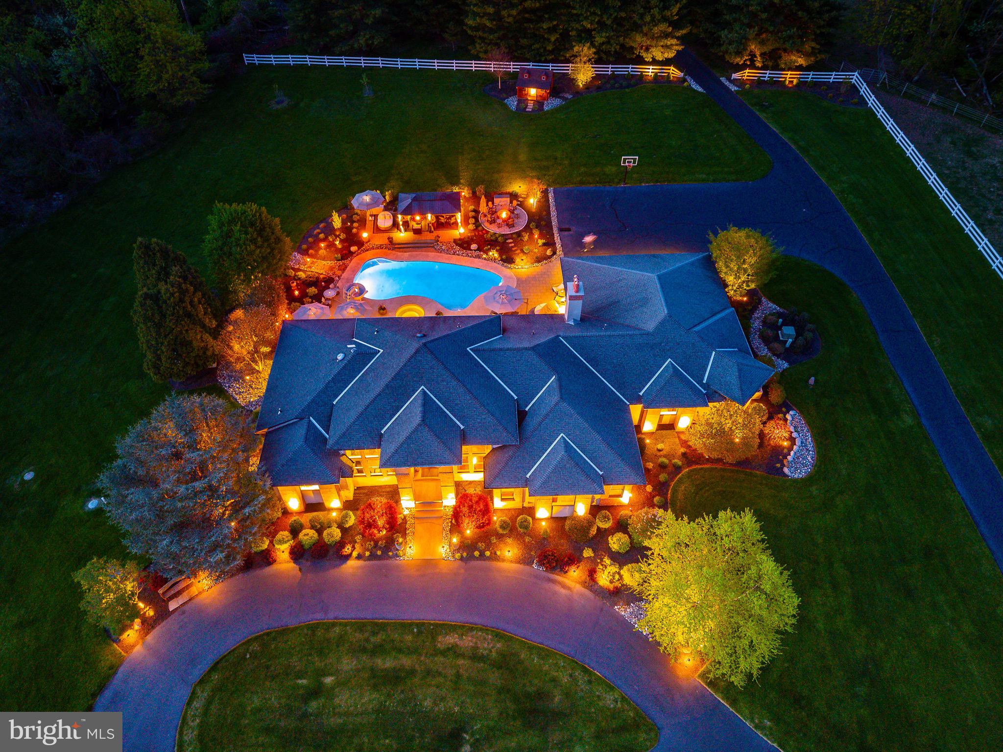 Welcome to one of Hilltown Township's most extraordinary luxury estates, where timeless elegance, unmatched craftsmanship, and resort-style living come together on a breathtaking private setting. A once-in-a generation opportunity to own one of Bucks County's most spectacular custom estates, designed to impress at every turn.  The home is set against the backdrop of sweeping panoramic vistas, this 11 acre plus gated estate perfectly blends natural beauty, refined living, and premier equestrian amenities. A long, picturesque gated driveway leads you to the main residence, where expansive windows and outdoor living spaces capture stunning views from every angle rolling hills, open meadows, and spectacular sunrises and sunsets. Whether you're  a car enthusiast, collector, hobbyist, this estate provides the flexibility to accommodate your lifestyle. 

This elegant residence offers a warm yet sophisticated ambiance with soaring ceilings, sun-filled spaces, and a seamless open layout designed for both everyday living and elevated entertaining. The heart of the home features a beautifully appointed kitchen, expansive great room, and dining area that flows effortlessly into the main living spaces, anchored by a striking fireplace and complemented by easy access to a covered patio. A custom wine room with rich wood built-ins and a dedicated tasting area adds an elevated touch perfect for collectors and hosting. A distinguished executive home office featuring built-ins, premium finishes, and a quiet executive ambiance perfect for working from home. An elegant formal living and dining room offer timeless sophistication and exceptional flow for entertaining with family and friends. 

The outdoor living experience is truly exceptional, designed as a private resort. The heated in-ground pool with spa, (which can stay open year round due to separate pump and filter system), water features, and slide is surrounded by stunning hardscaping and ambient lighting. A beautifully crafted pavilion with lounge seating and a fire feature creates the perfect setting for entertaining or relaxing under the stars, offering a level of outdoor living that feels both luxurious and inviting.

For equestrian enthusiasts, the property is thoughtfully equipped with a well-appointed barn offering multiple stalls, a tack room, and storage. Expansive fenced pastures, turnout areas, a lean-to shelter, and an oversized riding ring provide an ideal setup for riding, training, or leisure. The acreage also allows for additional animals, gardens, outbuildings, or even a future guest house.

The grounds are meticulously maintained with extensive landscaping, hardscaping, miles of quality fencing, and a full irrigation system (excluding turnouts), all controlled through the Rain Dance app.

Modern technology enhances the home with whole-home audio powered by seven Sonos amps, smart lighting, Roku entertainment, and a commercial-grade WiFi network with multiple access points for seamless coverage throughout the home, grounds, and pool area, plus a backup Starlink system. This property has a 40 year Premier brand roof, 400 amp service, and 3 electrical panels. 

Security is comprehensive with Nest cameras, a high-tech gated entry system with video, voice, and keypad access, and a commercial-grade Verkada system. The pool is fully controlled via the Pentair app. Both the home and barn include monitored fire and CO2 systems, with lightning protection installed at the barn.

A dedicated theater room with zero-throw projection and surround sound, along with an additional system in the family room, completes the home’s entertainment offerings.

Ideally located in Hilltown, overlooking Roxborough and beyond, this private estate offers convenient access to Philadelphia, New York, and New Jersey, all within a top-rated school district.

Rarely does a property of this caliber become available offering a lifestyle defined by privacy, elegance, and exceptional indoor-outdoor living.