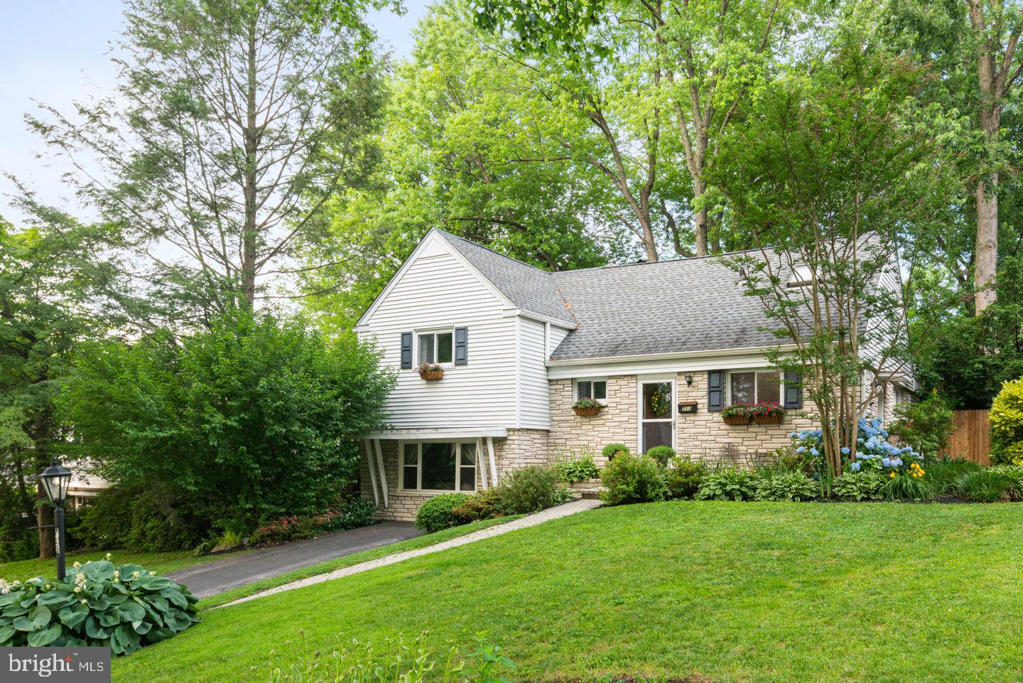 Stone front, split-level home in highly desirable Mainline location! Follow the brick paver walkway to the front entrance and enter the tile foyer w/conveniently located powder room. Step into the open and expanded living room with brick fireplace, gleaming hardwood floors, recessed lighting, and picture window with views of backyard and swimming pool. Even more natural light shines in the skylight to dining room which compliments the flow and energy of this inviting living space. Eat in kitchen also opens to the dining room. Kitchen features tile floor, Corian counters, stainless steel stove and a pantry closet. Exit from the dining room to the patio, a beautiful and easily accessed outdoor living space great for entertaining or relaxing. Upstairs you'll find spacious bedrooms and even more closet space- ample storage can be found throughout the home! Master bedroom is bright and updated with attractive flooring. Stylish hall bath includes dual sinks, quartz countertop, handsome cabinetry & glass doors on shower stall showcasing the tile work. Another bedroom on this level provides an opportunity to create a larger master suite. Upstairs another level reveals two more spacious bedrooms and full bath with skylight! One of the bedrooms could make a great den or office w/hardwood floors enhancing the space. On the lower levels this home offers even more size and room! The family room has upgraded flooring, built in shelving and bar area, a cozy window seat, and exits to the rear laundry room and fenced swimming pool. The swimming pool and surrounding patios blend nicely with the mature landscape ensconcing the back yard. The basement level of the home is also finished and has a large open space in addition to a smaller craft room with closet. This property is well maintained and has newer mechanical systems. The location provides easy access to Philadelphia for car or rail commuters, and is served by Lower Merion School District and its award winning schools