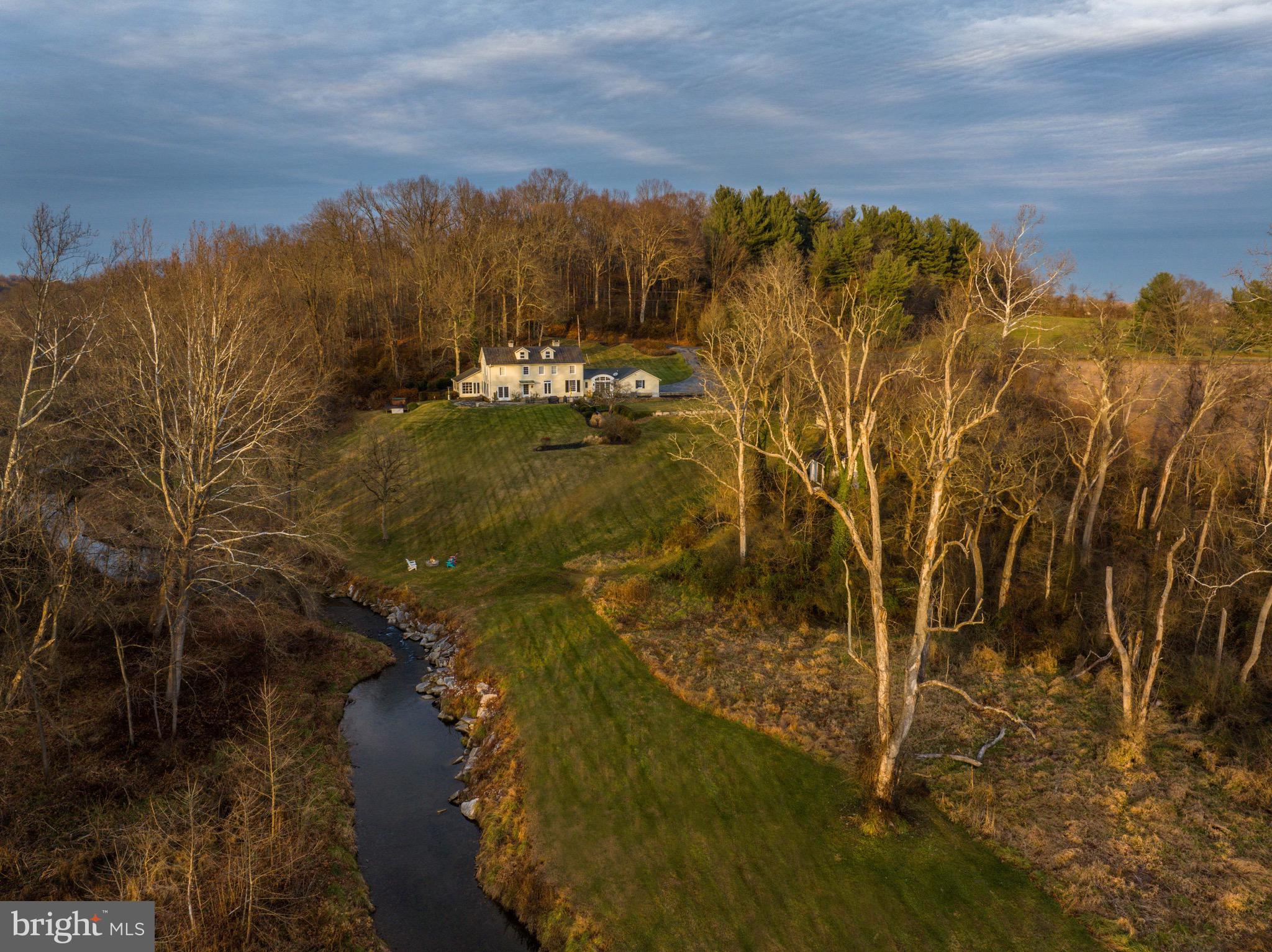 Live Authentically. A magnificent setting in the heart of Worthington Valley. A 1930's farmhouse sited exquisitely with electric sunset views overlooking a robust stretch of the Western Run River. Thoughtful renovation designed by Laura Thomas. A serene first floor owners suite encourages restful slumber. Swing open the doors... let the sounds of the river lull you to sleep. Wake up refreshed and relish the panoramic vistas from your bed and beyond. Perched on 6.6 glorious acres. Nestled along a picturesque lane, a medley of unparalleled countryside beauty awaits you.  Extraordinary river vistas are revealed. Live in tune with the rhythm of nature. Incredible Eagles nest on property. A cooking space as bright as it is functional. A feast for the senses. Each window punctuates to frame a view. Small barn that has been transformed into a gym. Luxe chicken coup.  Built on axis, an eastern facing front door, expansive stone terrace facing west, positioned with a commanding view of the river. Fresh, clean palette. A property with intrinsic value that will still be palpable 50 years from now.  Continue your journey of tranquility as you meander and take a hot tub with a view. Waltz with the rolling hills and the river's edge. Boundless enchantment radiates here. The canvas is yours. Express yourself.  An unfinished 3rd floor awaits your vision. Cultivate your existence. The art of uniting human and home.
