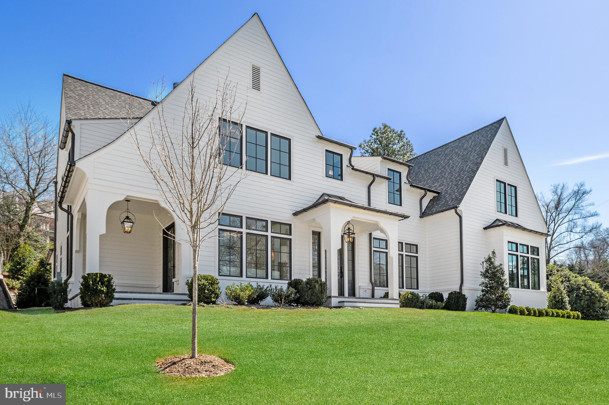 3433 N Albemarle St is a brand new designer showpiece home sited on a picturesque 0.39-acre corner lot in Country Club Hills, one of the most sought-after neighborhoods in Arlington, VA. This home was designed and developed by Rosewood NB, built by Thorsen Construction, Architected by Harrison Design, and landscape design by Joseph Richardson Landscape Architecture. The 8,600 SF residence offers flexibility with its curated interior spaces and offers incredible scale with 10’ ceilings on the Main Level, 9’ on the Second Level, and 9’8 on the Lower Level. No detail is left untouched with custom finishes including Designer Lighting Fixtures sourced from M&M Lighting, and custom inset designer cabinetry by Jean Stoffer Design and Stoffer Home Cabinetry throughout. The Main Level Foyer is flanked by the Formal Living Room with direct access to the side flagstone patio, and the Dining Room with access to the Butler’s Pantry Bar. The Gourmet Kitchen opens to the Breakfast and Family Rooms with SubZero Refrigerator/Freezer, LaCanche 7-burner gas range with double oven and griddle and plaster hood, 2 Miele Dishwashers, large island with Calacatta Lincoln Marble countertops, Jean Stoffer Cabinetry, Perrin and Rowe and Rohl Fixtures, wet bar, Butler’s Pantry Bar with 2 wine coolers and hammered-nickel sink, and more. The Family Room is warmed by the wood-burning fireplace with gas line with a custom design fireplace surround made of Nero Marquina Marble, and the Wood Beams and Brackets on the ceiling provide additional drama and detail. The walkout rear flagstone-covered patio includes a built-in wood-burning fireplace and access to the serene rear garden. The Main Level continues with a separate Bedroom Suite and Study space designed to accommodate a dynamic lifestyle. The Second Level is complete with  5 Bedroom Suites, each outfitted with walk-in closets and uniquely designed bathrooms expanding the custom design feel into the secondary spaces if this home. The elegant Primary Suite opens to the Primary Bath with large soaking tub, walk-in glass shower with Marble Waterfall Edge Shower Bench and built-in niche, separate Jean Stoffer Design Vanities, and access to the extensive walk-in closet, and views of the front and rear gardens. The 4 Secondary Bedroom Suites all include custom Masland carpet. The Laundry Room includes LG ThinQ Washer and Dryer, White Carrera Marble Countertops, sink, and 2 laundry cart nooks. The Lower Level opens to the substantial Recreation/Media Room with Surround Sound Prewiring and access to the Bar Room with French Eurocave Royale Temperature-Controlled Wine Cabinet, 2 refrigerator drawers, Miele dishwasher, and Calacatta Vagli Marble countertops. There is an additional Bedroom as well as a Bonus Exercise/Flex Room and several finished storage rooms on each floor. The two separate garages hold 3 cars and open to the Mudroom with Powder Room, built-in desk workspace, and access to the Rear Garden and Gourmet Kitchen. On each level, there is an elevator-ready shaft for potential installation. Just one stoplight to Washington, DC, this home is centrally located near the Washington Golf and Country Club, Langston Blvd Commercial Corridor, McLean, Tyson’s Corner, and the many miles of trails and parks in Arlington County. Must see!