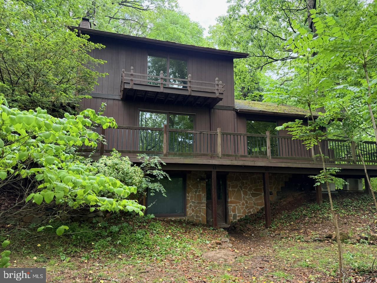 Set on 3.93 wooded acres at the end of an unpaved road, this contemporary home offers privacy and significant potential for the right buyer. Built in 1979 and offering 1,861 square feet above grade across two stories plus a full basement, the home retains many of its original architectural features and is being offered as-is. The main living level opens to wraparound decking overlooking mature woodland on all sides, with multiple sliding-glass doors and large windows bringing natural light into the principal rooms. Interior highlights include a floor-to-ceiling stone fireplace in the main living area, a second living space with a freestanding wood stove on a stone hearth, an open kitchen with solid-surface stone countertops and wood cabinetry, and an upper-level room with a vaulted wood-paneled ceiling, skylight, and a second wood stove. A spiral staircase connects the levels, and hardwood flooring runs throughout much of the home.  The property is located in the Perkiomen Valley School District. The home reflects its 1979 era and will require updating and repairs throughout, including cosmetic finishes and attention to the exterior and roof. It represents a strong opportunity for an investor or a skilled homeowner prepared to renovate and build equity in a private, low-traffic setting on a sizable acreage parcel. Buyer to verify all room counts, square footage, systems, and property condition through independent inspection. This is a Department of Housing and Urban Development (HUD) property (Case#  441-949560).  Important Notice: This property is being sold as-is, with no guarantees or warranties provided. Utilities are turned off, so please exercise caution when viewing the property. Daylight showings are recommended. All property details, including disclosures, the Property Condition Report (PCR), sale contract, and sale process, are available on HUDHomestore.

Buyers are responsible for any costs associated with activating utilities for inspections, if permitted. If the plumbing system fails the pressure test, water cannot be activated for inspections. Additionally, any required Use & Occupancy (U&O) inspections are the buyer’s responsibility and expense.

For financing and closing, FHA and conventional loans must close within 45 days, FHA 203(k) financing within 60 days, and cash offers within 30 days. The buyer is responsible for all closing costs, including transfer tax. The property is considered to be FHA Insurable with Escrow (IE, subject to appraisal).  The final escrow amount is subject to lender determination.

This is an Equal Housing Opportunity property.