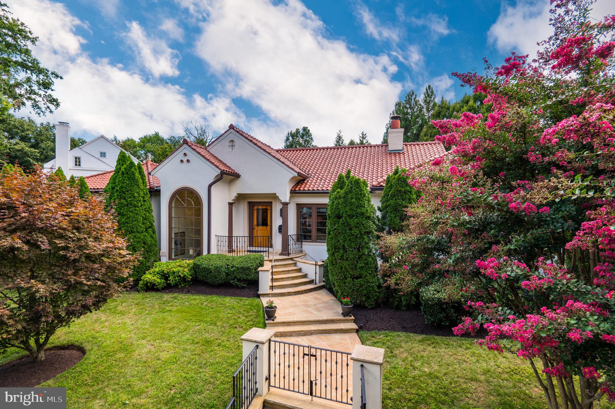 Exquisitely designed and boldly executed on a one third acre lot in the Village of Chevy Chase sits a beautiful white stucco Mediterranean style residence with a red tile roof. Meticulously maintained with spacious room proportions, custom finishes and cascading light, this five-bedroom, four full bath abode features a gracious foyer, gourmet kitchen, generous morning room, expansive family room, banquet sized living and dining rooms, and a luscious primary suite. The lower-level game room, family room with wet bar and two bedrooms doubling as an office and guest suite allow for private family entertainment sequestered from day-to-day family operations.  Completing this level is a full catering kitchen with dual washers and dryers, a folding/kitchen prep island and frosted glass pocket doors. 

The exterior is complemented by specimen plantings, landscaped grounds and Teakwood sandstone walkways, terraces and retaining wall capstones. A completely private rear garden with pergola, a two-car detached garage and a driveway with motorized security gates complete this ideally situated home