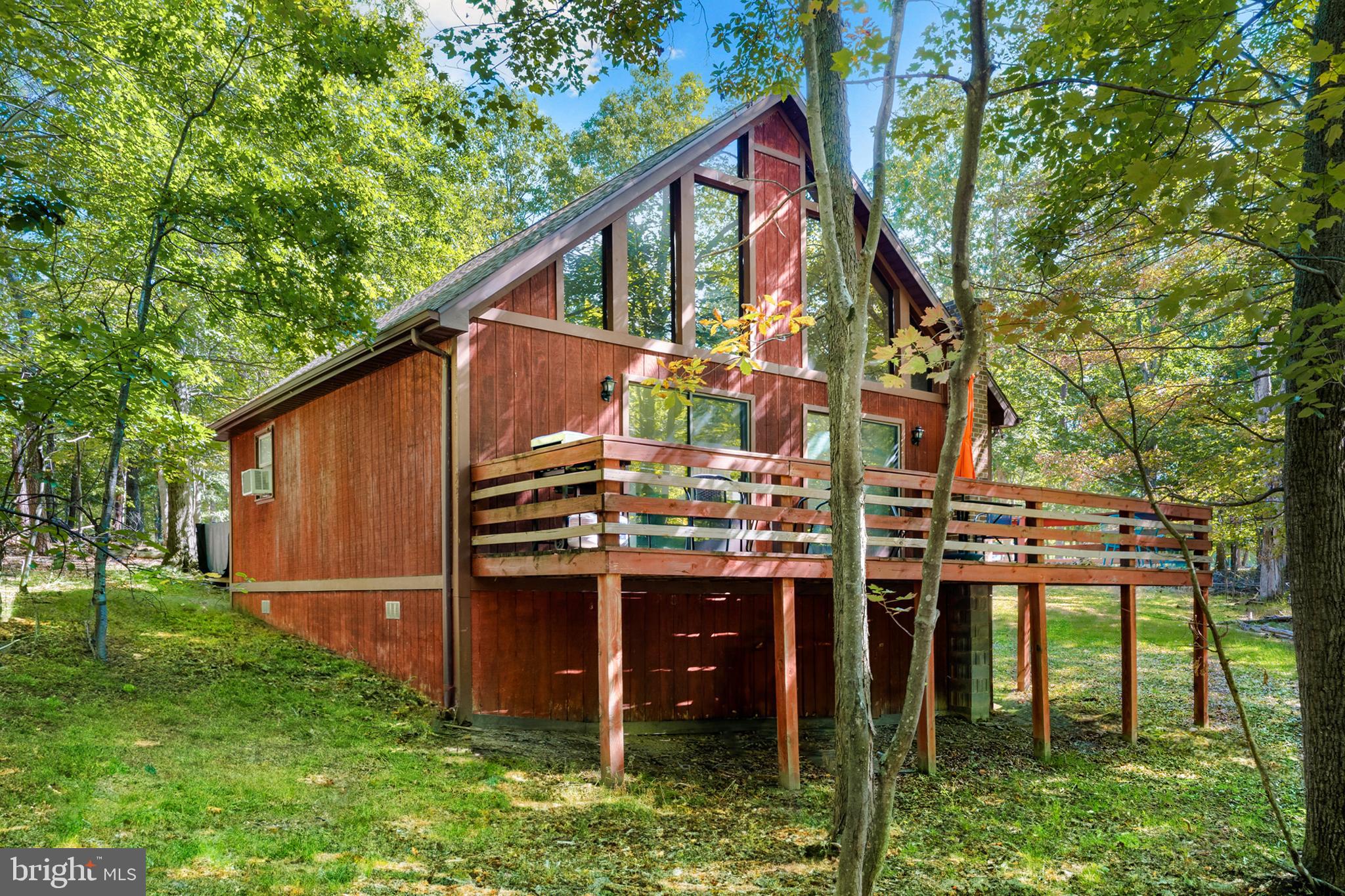 Beautiful 2-bedroom, 1-bath chalet cabin tucked away in the woods of Berkeley Springs. With its tall ceilings, abundant windows, and open, airy feel, this home is designed to bring the outdoors in. The seller has thoughtfully invested over $47,000 in upgrades, ensuring the home combines comfort and style while creating the perfect getaway for relaxation or adventure. The spacious open loft adds to the charm of this home, providing a versatile space that can be used as a bedroom, office, or cozy reading nook. Step outside onto the expansive deck, perfect for entertaining or relaxing in the brand new hot tub. And just a short walk from the cabin is Sleepy Creek, where you can enjoy fishing or tubing in the summer.  Located just minutes from all the attractions that make Berkeley Springs a sought-after destination, you’ll have easy access to golfing, fishing, hiking, restaurants, and local shops. The property has proven to be a highly successful vacation rental, generating $46,000 annually in rental income ($128k over the past 30 months!).  Whether you're looking to make this your personal retreat or continue its legacy as a profitable vacation rental, this property offers a unique opportunity for both. Plus, the cabin comes with the option to retain the existing property manager and cleaner, making it a hassle-free, turnkey investment.  Hot tub and furniture optional, available for purchase.  See seller docs for a summary of rental history and financials.  $1,000 buyer credit if you continue using the same property manager.