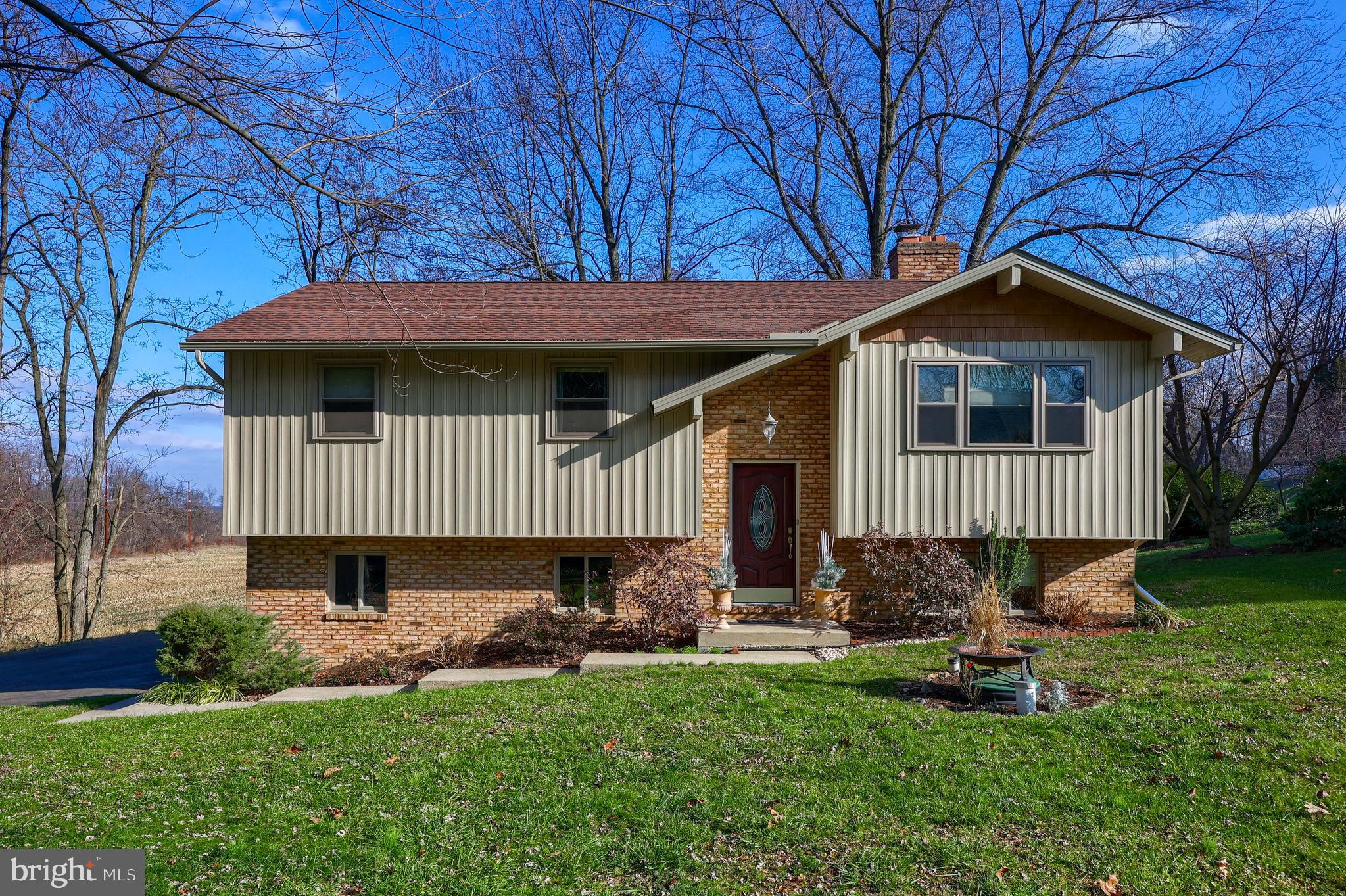 This lovely West Hempfield Bi-level offers 3 bedrooms (possible 4th in the lower level), 1.5 baths, 2-car garage, 1/2 acre lot, and large rear yard perfect for fun and entertainment. Recent updates include a roof, windows, appliances, and siding. A charming brick double-sided fireplace divides the family room and dining room, and a bright sunroom gives way to scenic views to the backyard. Enjoy the gorgeous scenery from across the neighboring farmland or relax in the backyard. This home is conveniently located close to schools, shopping, parks, restaurants, major highways, and it's a quick walk to Grubb Lake Nature Park.