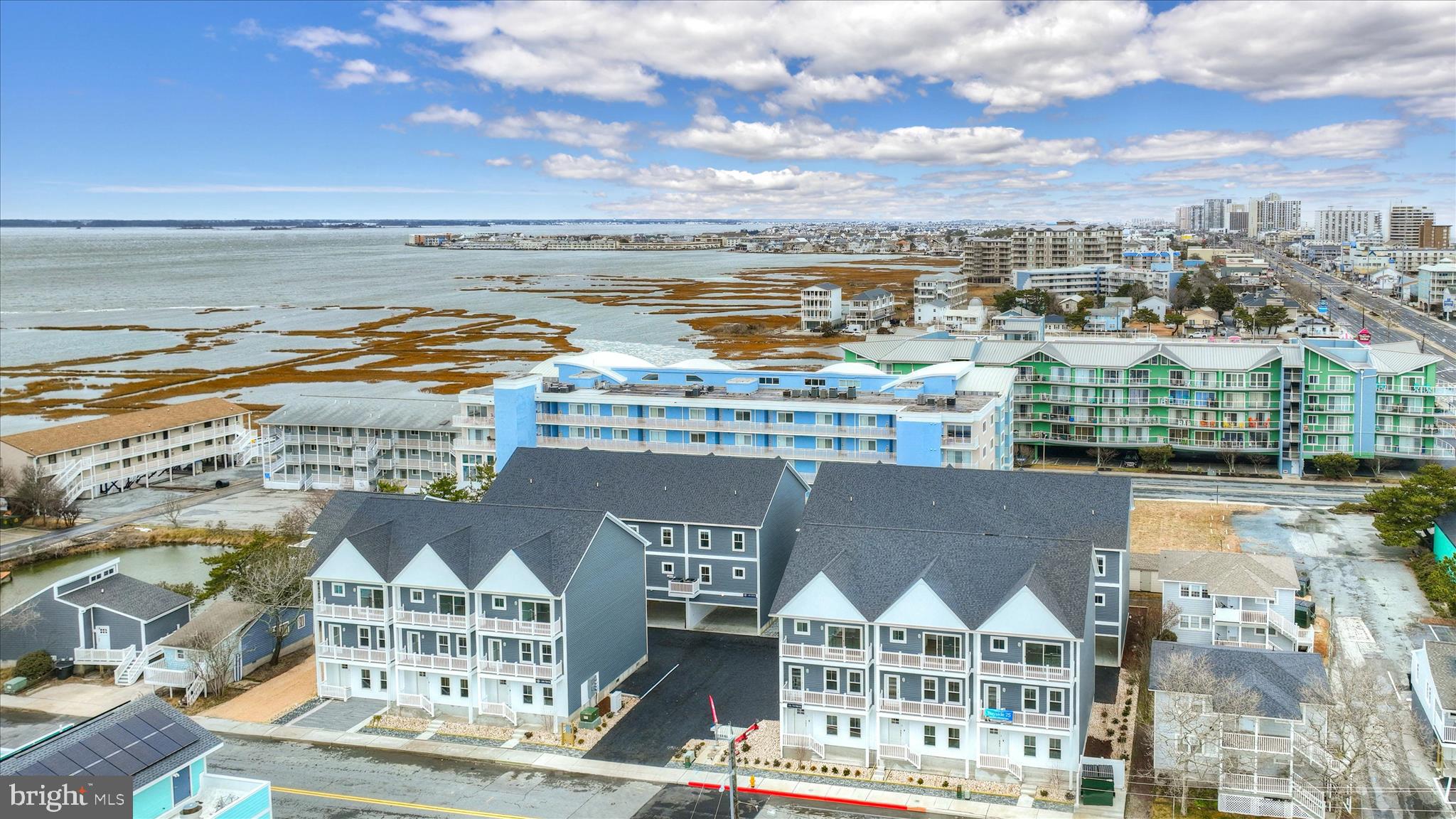 **** Furnished Models open daily 11-2 ****  Welcome to Bayside 75, where luxury meets the laid-back rhythm of coastal living in the heart of Ocean City. This exclusive 14-residence townhome enclave offers a rare opportunity to own a brand-new, fully furnished, professionally designed retreat in one of Midtown’s most sought-after locations. From the moment you arrive, this stunning, 4-bedroom, 4-bathroom three-level townhome delivers style, comfort, and effortless beachside living at every turn. A charming covered front porch welcomes you in, leading to a private entry-level bedroom complete with ceiling fan and a beautifully appointed ensuite bath featuring a sleek tiled shower, perfect for guests or a private retreat.
Upstairs, the main living level is an absolute showstopper! Sun-drenched and spacious, the open-concept design is made for entertaining and relaxing alike. The expansive living room has balcony access, ideal for catching coastal breezes and enjoying tranquil bay views. The designer kitchen is equally impressive, showcasing crisp white cabinetry, a stylish tile backsplash, recessed lighting, and eye-catching pendant lights over the breakfast bar. It opens effortlessly into a generous dining area, creating the perfect gathering space. A full hall bath adds convenience to this level.
The top floor continues to impress with a luxurious primary suite featuring its own private balcony with bay views, a walk-in closet, and a beautifully finished ensuite bath. Two additional bedrooms, each with ceiling fans, are complemented by a well-appointed hall bath, while a convenient upstairs laundry room adds everyday ease. Throughout the home, custom closet organization systems maximize storage, and rich, warm-toned luxury vinyl plank flooring adds an elevated, cohesive feel.
Additional highlights include a spacious two-car garage and truly turnkey convenience, this home is being sold fully furnished with professionally curated interiors, allowing you to start enjoying it from day one!
Whether you're seeking a full-time residence, the perfect vacation escape, or a high-performing investment property, this home checks every box. Ideally located in Midtown Ocean City, you’ll enjoy easy access to quieter beaches, beloved local attractions, and some of the area’s best dining. And for boating enthusiasts, a public boat launch just steps away at the end of the street makes getting out on the bay effortless.
This is coastal living at its finest, stylish, turnkey, and perfectly positioned. Bayside 75 is more than a home… it’s a lifestyle!