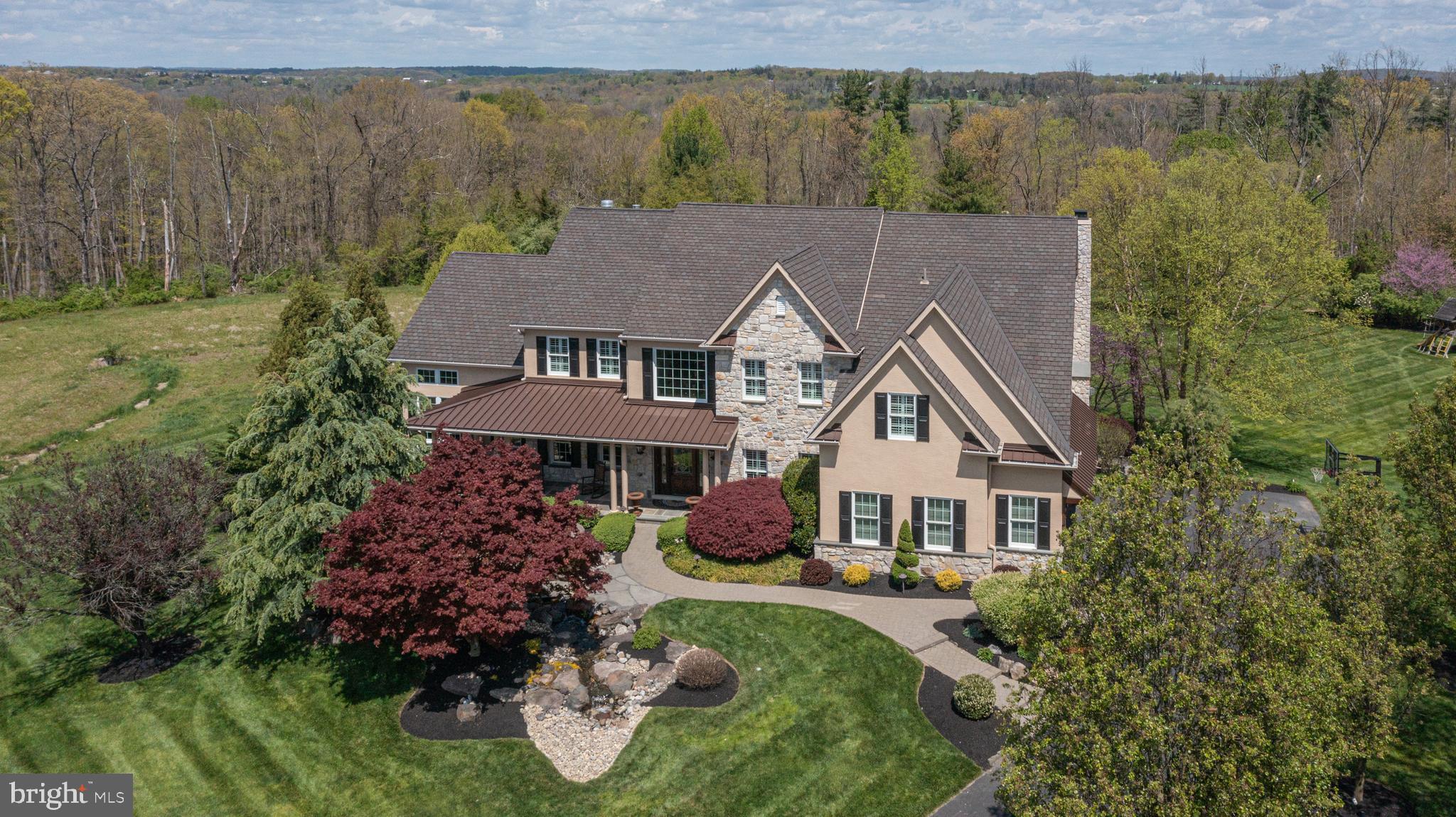 Backing to 100+ acres of preserved land and open space, this Estates at Dark Hollow beauty is a rare and special find. Nestled on a prime cul-de-sac lot in a serene setting, this renovated and expanded 5 bedroom, 4.5 bath home checks off everything on your wish list and more!  Its professional hardscape and landscape elements, including a tranquil waterfall near the front walkway captures your attention and lures you inside to discover even more impressive and remarkable features of this charming home. An abundance of natural light and openness surround you as you step in from the stunning blue stone porch into a welcoming two-story foyer adorn with a gracefully curved staircase and flanked by a wainscoted formal dining room with extensive moldings and private, two-door entry study making a perfect work-at-home setting. Follow the hand-hewn hardwood floors which guide you to the heart of the home; the open concept family room and grand gourmet kitchen. Certainly a chef’s pleasure, the expansive kitchen showcases an abundance of cherry cabinetry, large breakfast nook, an oversized island with seating for four, granite counters, coffee station and a suite of high-end, stainless-steel appliances. The breakfast area offers convenient access to the rear, upper deck from its oversized slider and leads seamlessly to the soaring two-story family room adorn with second staircase and wall of windows where family and guests can gather around the cozy floor-to-ceiling, gas fireplace on chilly evenings creating the perfect ambiance for relaxation. Utilized in diverse ways, the neighboring conservatory is a notable space with its three walls of windows, grand vaulted, wood trimmed beamed ceiling, stone fireplace and built-in bar area. Completing the main level is a convenient half bath and spacious laundry/mud room. Residing upstairs at the top of the landing is the double-door entrance to the primary suite with an eye-catching tray ceiling, sitting area, plantation shutters and large walk-in closet. Indulge yourself in this main master bath highlighting a platform Jacuzzi tub, oversized walk-in shower, and dual sink vanity. A spacious ensuite bedroom can also be found on this level as well as two other bedrooms which share a convenient Jack and Jill bath. Downstairs, the finished walkout lower level offers additional living space including a full bath, bedroom, media room, billiards/game room, exercise room and ideal storage. Outside an enormous backyard oasis is a dream come true with inground pool adorn with waterfall and hot tub, entertainment areas including a covered, upper deck sitting space with stone fireplace and lower expanded patio area boasting a kitchen/prep area with window seating, Jacuzzi and built-in grill. Located in a highly desirable, quiet neighborhood in Jamison with many entertainment and dining options in nearby Doylestown and Newtown. Come tour and enjoy breathtaking views from every window of this exquisite home today!