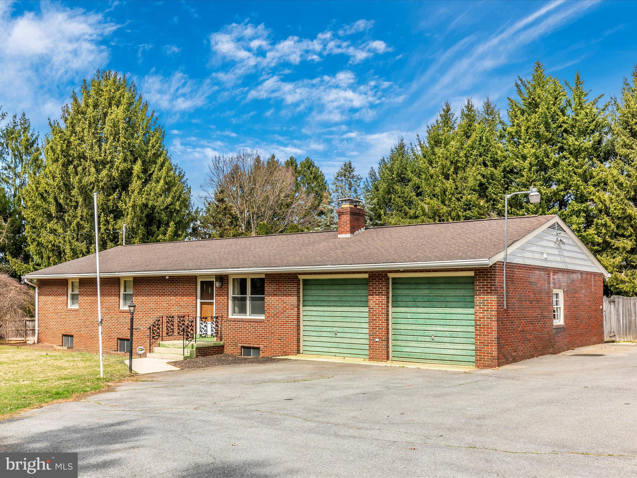 This charming and spacious brick rancher is nestled on a picturesque one-acre lot, surrounded by mature trees for ultimate privacy. Step inside to discover stunning hardwood floors throughout the main level, where a generously sized living room with a cozy wood-burning fireplace flows seamlessly into the dining room, complete with access to the rear patio—perfect for entertaining. The vintage kitchen is a true gem, featuring an incredible retro stove with a double oven, an updated dishwasher, a cozy breakfast nook, and ample cabinetry for all your storage needs. The main level boasts four comfortable bedrooms, including a primary suite with a private bath and double closets. A convenient main-level laundry room adds to the home's practicality. Downstairs, the fully finished lower level offers an ideal in-law suite with a full kitchen, full bath, spacious living room, and two additional rooms—perfect for an office, gym, or creative space. Outside, you'll find a huge patio, plenty of space for gardening, a circular driveway, and a two-car garage. Ideally located in a serene setting yet just minutes from town and major commuter routes, this home perfectly blends privacy, convenience, and timeless appeal!