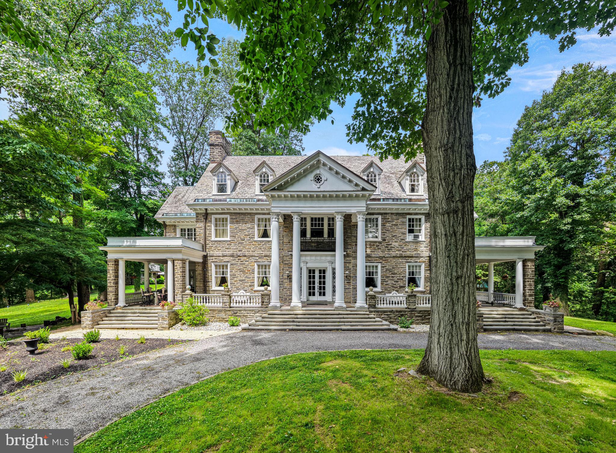 Designed by the Philadelphia firm of Savery & Scheetz for its wealthy industrialist namesake, the Houstonia mansion impresses at every turn. No detail was spared in this 22-room estate - you'll find all of the grace and charm of the time period intact with tasteful and modern updates, making the home both a lovely endeavor in preserved history and well-suited for today's discerning buyer. With an incredible amount of original architectural elements whose quality in craftsmanship and detail is a rarity in today's builds, the home is quintessentially Neoclassical. Ascend the bluestone terrace with Juliet balcony & soaring 2-story portico & discover its grandeur. French doors open onto a magnificent reception hall, whose wide stair & Palladian window half-story landing fills the space below with natural light. Gleaming hardwood floors, handsome wainscoting, detailed millwork, pocket doors, stunning light fixtures & quality materials set the tone for this home.  A very large, full-depth living room with gorgeous soapstone hearth fireplace is located to the hall's left. It serves as a lovely gathering room, providing access to both the terrace & sunroom. To the right of the center hall, you'll find the office & an arched passageway to the home's beautiful dining room with a second soapstone hearth fireplace. The generously-sized butler's pantry with beverage refrigerator, a second dishwasher and abundant storage is adjacent, followed by the kitchen with gorgeous cabinetry, stainless steel built-in kitchen aid appliances, huge island, and many gourmet amenities! A  mudroom is located just beyond the kitchen & makes a lovely transition to the back stair hall and side porch entry. The stairs provide convenient & informal access to the bedroom wing above; here you'll find 5 bedrooms, a den, 3 full baths, laundry room & stair access to the 3rd story. Continue across the main stair hall to find the sizable owners suite with en suite bath, large dressing room which formerly served as a sleeping porch walk-thru closets. The finished 3rd story includes a bedroom suite ideal for guest or perhaps an au pair, bonus rooms, walk-in cedar lined storage rooms, and a billiard room which now serves as a fabulous family room. A large, detached carriage house with three heated garage bays is located on a separately deeded tax parcel and is included with this property. The carriage home residence serves perfectly as an in-law suite, or a rental. With hardwood floors throughout, it boasts an eat-in kitchen, great room, family room, 2 bedrooms, hall bath and deck. With five acres of gorgeous private grounds, including a former green house, Houstonia is also surrounded by an oasis of township parkland in Wallingford. This location provides convenient access to the Philadelphia Airport, SEPTA train stations, Media Borough, and a myriad of retail and commercial centers.