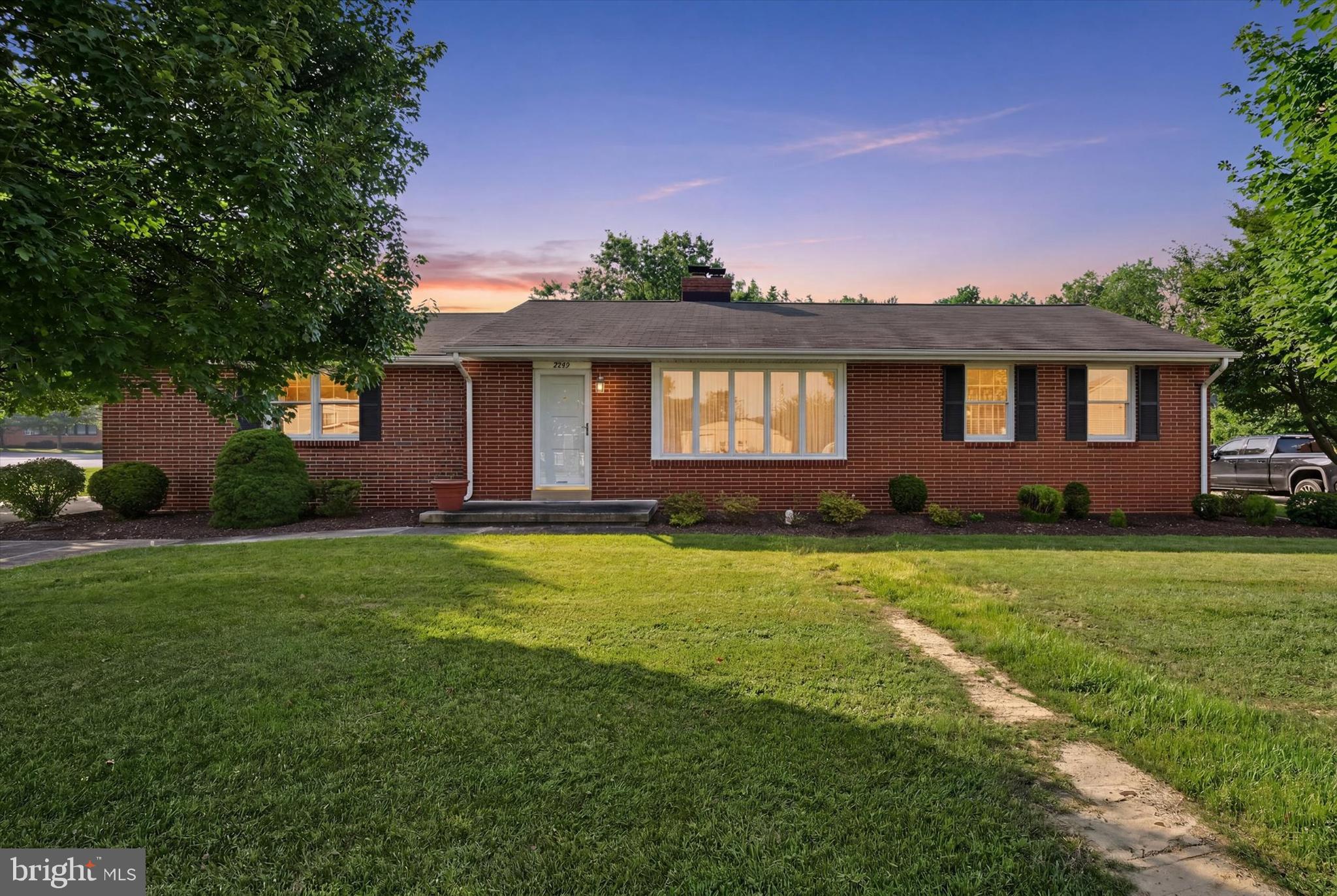 Welcome home to this beautifully maintained all-brick rancher, proudly offered for the first time by its original owners. Built in 1959, this timeless home has been lovingly cared for throughout the years and offers a wonderful combination of classic character, comfortable living spaces, and endless potential.

Step inside to a spacious living room featuring a large picture window that fills the space with natural light, plush carpeting, and a cozy wood-burning fireplace with a brick surround and mantel—creating the perfect gathering place. Just off the kitchen, the inviting family room offers a second wood-burning fireplace with a raised brick hearth and brick surround, ceiling fan, and sliding glass door leading to the backyard and expansive concrete patio, making indoor and outdoor entertaining effortless.

The kitchen provides an abundance of oak cabinetry, generous countertop workspace, a double sink positioned beneath a window overlooking the backyard, and all appliances convey. Three generously sized bedrooms feature beautiful hardwood flooring and share a well-maintained full bath.

The partially finished lower level expands your living space with a recreation area, convenient half bath, laundry area, abundant storage, and a walk-up exit to the backyard.

Outside, you'll appreciate the level lot that backs to mature trees, offering a peaceful setting. The oversized concrete patio is ideal for summer barbecues, relaxing evenings, or entertaining family and friends. A detached one-car garage provides additional storage and includes a versatile upper-level room accessed by exterior stairs—perfect for a workshop, hobby space, or extra storage. 

Solidly built and exceptionally well maintained, this home is ready for its next chapter. Offered in very good condition and being sold as-is, this is a wonderful opportunity to own a quality-built home with great bones in a beautiful setting. Being sold As-Is!  Schedule your private tour today!
