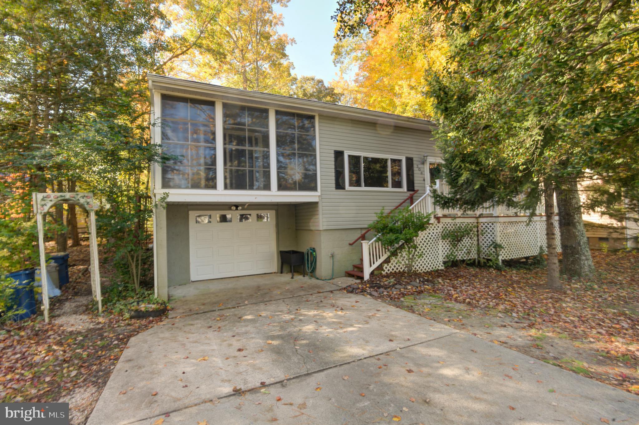 NEW PRICE! This home has many special features and is ready for immediate occupancy. This 3-bedroom and 2 full bath raised rancher has a big back enclosed porch, a front enclosed porch and two decks- one in the front and 1 in the back. It has an unfinished basement for storage and a single car garage on the ground level.  New roof in the last 20 years and a new H/P. Newer cabinets and flooring in kitchen and dining area. There is a central vacuum system. Lots of storage space under the house. Gas fireplace in the spacious Living Room and a few steps up to the dining room and kitchen.  Laundry room has the access door to the garage and basement storage areas. Walking distance to White Horse Park for the playground, Farmer's Market on Saturdays, Gift Shop or outdoor concerts. Easy walk to the Swim and Raquet Club complex with pool and bay access with beach and docks, tennis courts and walking trail. Easy to see. Seller says bring all offers.