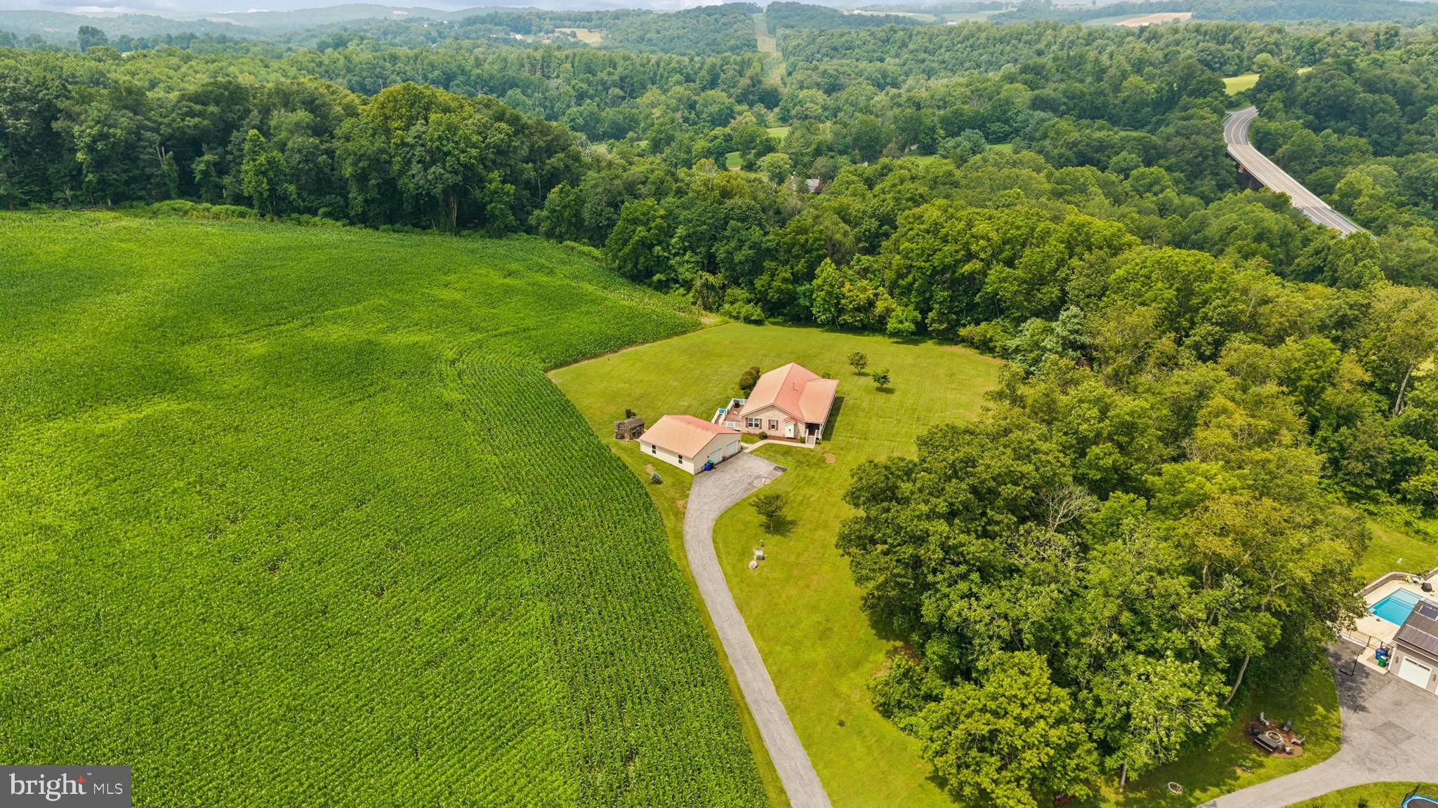 Nestled on 2.4 scenic acres, this well-maintained brick rancher offers the convenience of true one-level living in a peaceful country setting. Featuring 3 spacious bedrooms and 2 full bathrooms, this home welcomes you with beautiful hardwood flooring and a warm, inviting fireplace. The well-appointed kitchen boasts custom cabinetry, granite countertops, a gas range, a large pantry, and plenty of workspace for everyday living and entertaining. A convenient mudroom provides additional storage and functionality.

Step outside and unwind on the covered front porch or the rear deck while enjoying the privacy and tranquility of the surrounding landscape. The impressive 1,296-square-foot detached garage offers exceptional space for vehicles, equipment, a workshop, or your favorite hobbies. Energy-efficient geothermal heating and cooling provide year-round comfort, while propane services the range, fireplace, and water heater.

Whether you're dreaming of a small homestead or simply looking for room to spread out, the existing chicken coop makes it easy to embrace country living. With no HOA, you'll have the freedom to enjoy your property your way. Conveniently located just minutes from Routes 26, 75, and 70, this home offers the perfect balance of rural charm and commuter convenience.