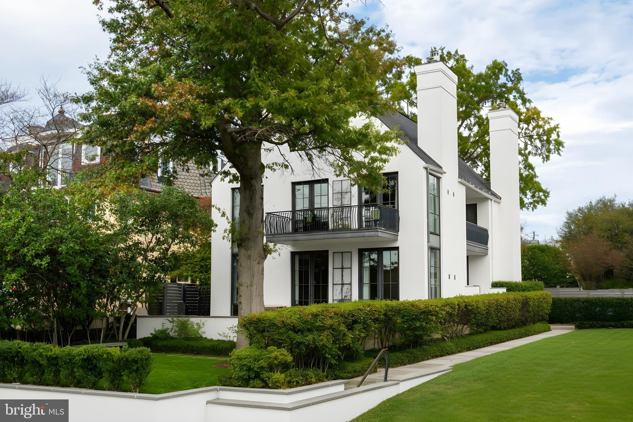 Perched high above the banks of the Potomac River on its namesake street in the heart of the Palisades neighborhood, 5431 Potomac Avenue NW stands at the apex of artistry, workmanship, and an unparalleled location. With unobstructed verdant views of the Virginia bank across, the home towers over the Capital Crescent Trail, Chesapeake and Ohio Canal, and expansive views in the winter, replaced by a kaleidoscope of vibrant shades in the warmer months. 
Envisioned in a distinct transitional style, the home’s simple stucco exterior is introduced by a geometric facade punctuated by unbroken, minimalist panes of glass. A private, zen-like front garden sits beneath a lush canopy and combines with a low-walled flagstone patio to create a sanctuary from which to take in the views. An ethereal black and white color palette carries through the light-filled, deceptively large interiors. Rich, dark stained hardwood floors complement dark framing on floor-to-ceiling windows and doors, with handsome millwork and accent lighting throughout. Two sets of French doors in the formal living room open onto the front patio, blurring the lines between indoor and outdoor living. A roaring fireplace and illuminated art niche add warmth and depth. A true functional work of art, the chef’s kitchen features frameless stacked cabinetry, glass-fronted and illuminated on the upper tier, accentuated by stunning brushed brass hardware and concealing ingenious storage solutions behind the unbroken marble slab backsplash. A comprehensive suite of state-of-the-art Wolf and SubZero appliances offers the ultimate in culinary gadgetry. An unbroken gridded wall of glass lines the main level’s substantial informal areas, comprising a generously proportioned family room and casual dining area. A private fireplace infuses coziness into the upper-level primary bedroom, which opens onto a private balcony with sweeping views from two sets of French doors. The dressing room contains extensive built-ins all neatly concealed by full-height doors, framing a large picture window. A blend of contemporary elements with classic materials and workmanship, the primary bath is clad in bold marble tile with an intricate mosaic wall behind the floating double vanity. The freestanding tub sits against a smoked mirror backdrop, and the walk-in shower is enclosed by a gridded glass door. Two additional bedrooms on the upper level are both luxuriously appointed, with one featuring a roaring fireplace and both sharing a bold bathroom. A convenient laundry room completes the level. 
Ascending to the top of the sky-lit stairs reveals two more generous bedrooms and a shared, fully-tiled bath with marble vanity. The lower level recreation room is equipped with a series of in-ceiling Sonos speakers and can be effectively utilized as a professional media room. Additionally on the lower level is a fully self-sufficient guest suite complete with kitchenette and full bath. A minimalist haven, the rear outdoor space revolves around a spectacular lap pool equipped with an automatic retractable cover, set against a linear fence and row of uplit trees. The patio consists of stone slabs with an interwoven turf grid in the quintessential Southern California style. A covered al fresco dining area greatly enhances outdoor entertaining utility, and the entire area is basked in warm ambient lighting after the sun sets. The home’s location is one nearly without peers, walkable to Claudio’s Table and Et Voila, as well as mere minutes to Virginia via Chain Bridge and Canal Road. A truly rare blend of curated interior spaces and uncompromising outdoor space, 5431 Potomac Avenue NW is undoubtedly one of Washington's hidden gems. *Make sure to see the video for the listing.