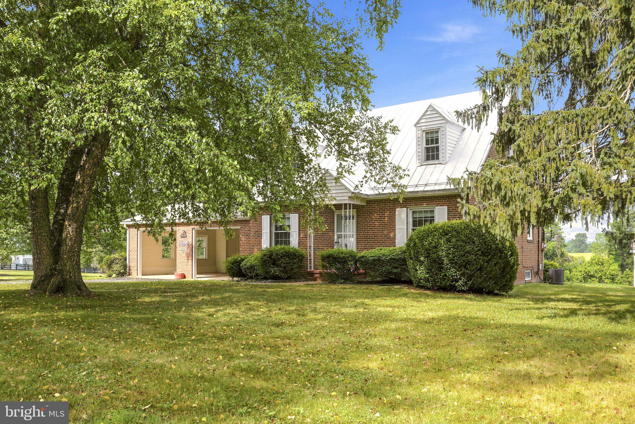 All brick Cape home and property in the Virginia Countryside just outside the town of Hamilton. Great location with paved roads and minutes to Leesburg. Beautiful lot just under 6 acres with barns and fencing for Horses, cows, chickens and more. The creek provides water for the animals. No HOA or covenants and restrictions. The white building is separate garage/workshop or possibly future cottage. Has electricity. Water faucet outside of the building. The home has a large two car garage, covered rear porch with fireplace. Metal roof on main part of the home. Inside hardwood floors most of the main level and upper levels. Main level with a bedroom and full bath. SS appliances in the kitchen. Propane tank is for cooktop in the kitchen. Sunroom addition off the back offer great views of the property. Upper level two bedroom and full bath. Ceiling fans in many rooms. Lower level has finished living space. Storage room to the walkup staircase. Oil heat and tank are owned. Multiple barns for equipment and animals.