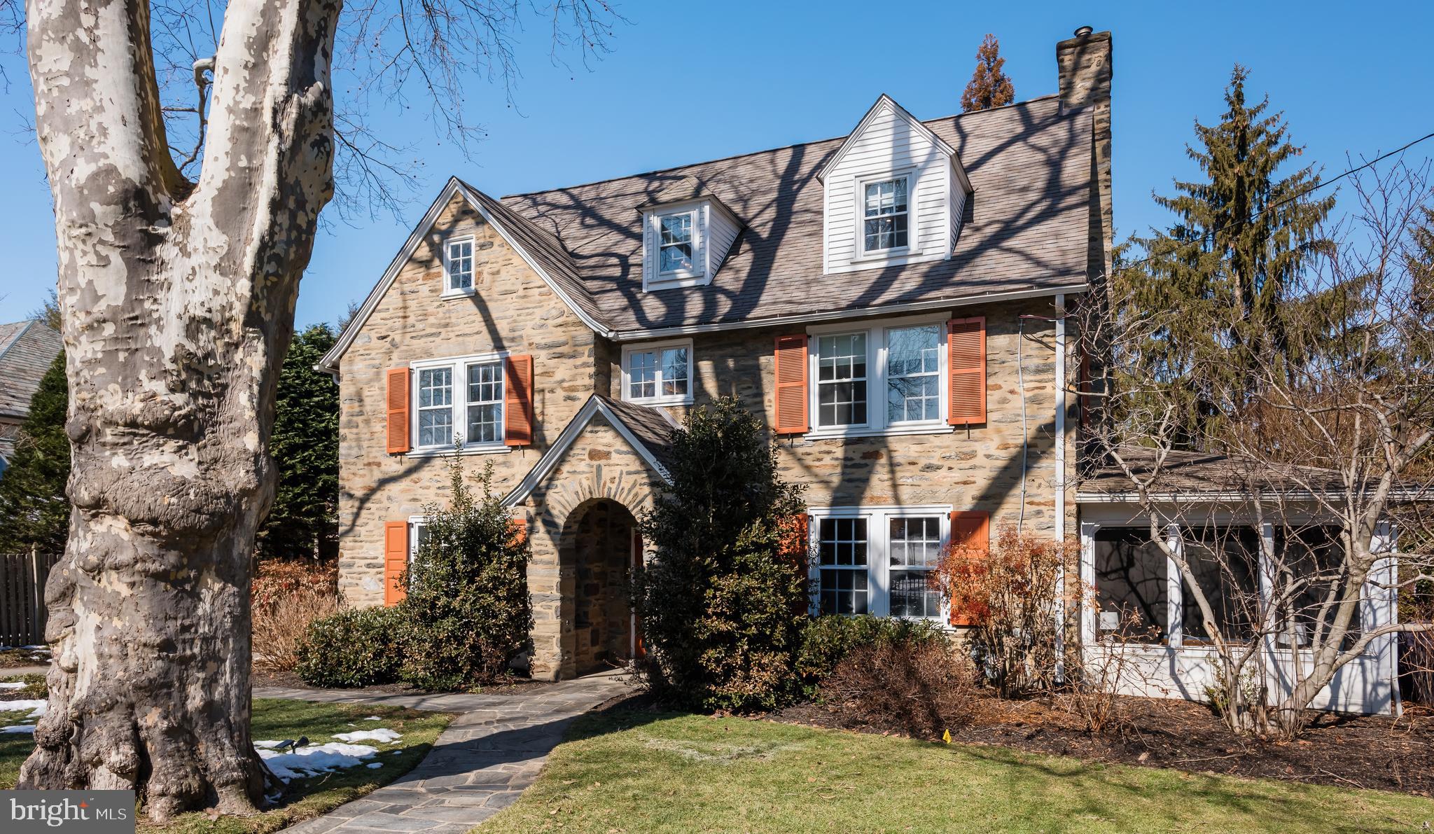 Perfectly set on its estate fenced, beautifully landscaped lot, this walk to Bryn Mawr, 6 bedroom Main Line stone colonial combines classic architectural charm with the generous living space of over 5400 finished square feet of modern comfort. From the moment you arrive, the home makes a striking first impression. Side-walked street with mature boxwood hedges framing the stone front, create natural beauty and privacy, while sturdy original estate fencing adds historic character. Its inviting curb appeal sets the tone for what awaits inside.
Step into a spacious entry foyer that immediately showcases its ample scale and character. This elegant welcoming space is perfect for greeting guests, setting the stage for the thoughtfully designed interior. Beyond the foyer, you’ll find spacious, light-filled rooms, gleaming hardwood floors, and a layout ideal for both everyday living and entertaining.
To the right, a gracious living room features a statement fireplace, classic built-in bookcases, and oversized windows that fill the space with natural light. The living room opens on both ends into an expansive private enclosed sunroom porch. To the left of your foyer, the formal dining room provides an elegant setting for holiday gatherings and dinner parties and connects to the kitchen through a butler pantry. 
The main living area is comprised of an open Kitchen to Breakfast Room to spacious Family Room floorplan. The expansive kitchen offers an abundance of cabinetry and generous counter space, providing both functionality and flexibility for everyday cooking and entertaining. It opens to a large skylighted dining area flowing to its generously sized family room with a fireplace and picture window, creating a natural gathering space. Large windows and glass doors invite natural light, The family room provides another access to the enclosed sunroom porch enhancing flow.
Upstairs, generously sized bedrooms provide comfort and flexibility for family, guests, or for home offices. On the 2nd floor, the primary suite serves as a tranquil retreat with ample closet space and a well-appointed bath. Three additional bedrooms. or offices if you wish, share an updated bathroom. The large 2nd floor laundry has natural light from its ample windows. Up on the 3rd floor are two large bedrooms that share a full bath.
The recently finished lower level adds approximately 850 square feet of versatile living space, complete with ample storage solutions and a convenient walk-out door providing direct access to the backyard, It is perfect for a media room, play area, or yoga workout. There is still plenty of unfinished storge space too.
Located within the award-winning Lower Merion School District and just minutes walk from Bryn Mawr with charming shops, dining, parks, and train stations, this home offers convenient access to Center City Philadelphia and major roadways. Enjoy the best of Main Line living in a property that blends privacy, space, character, and location.
