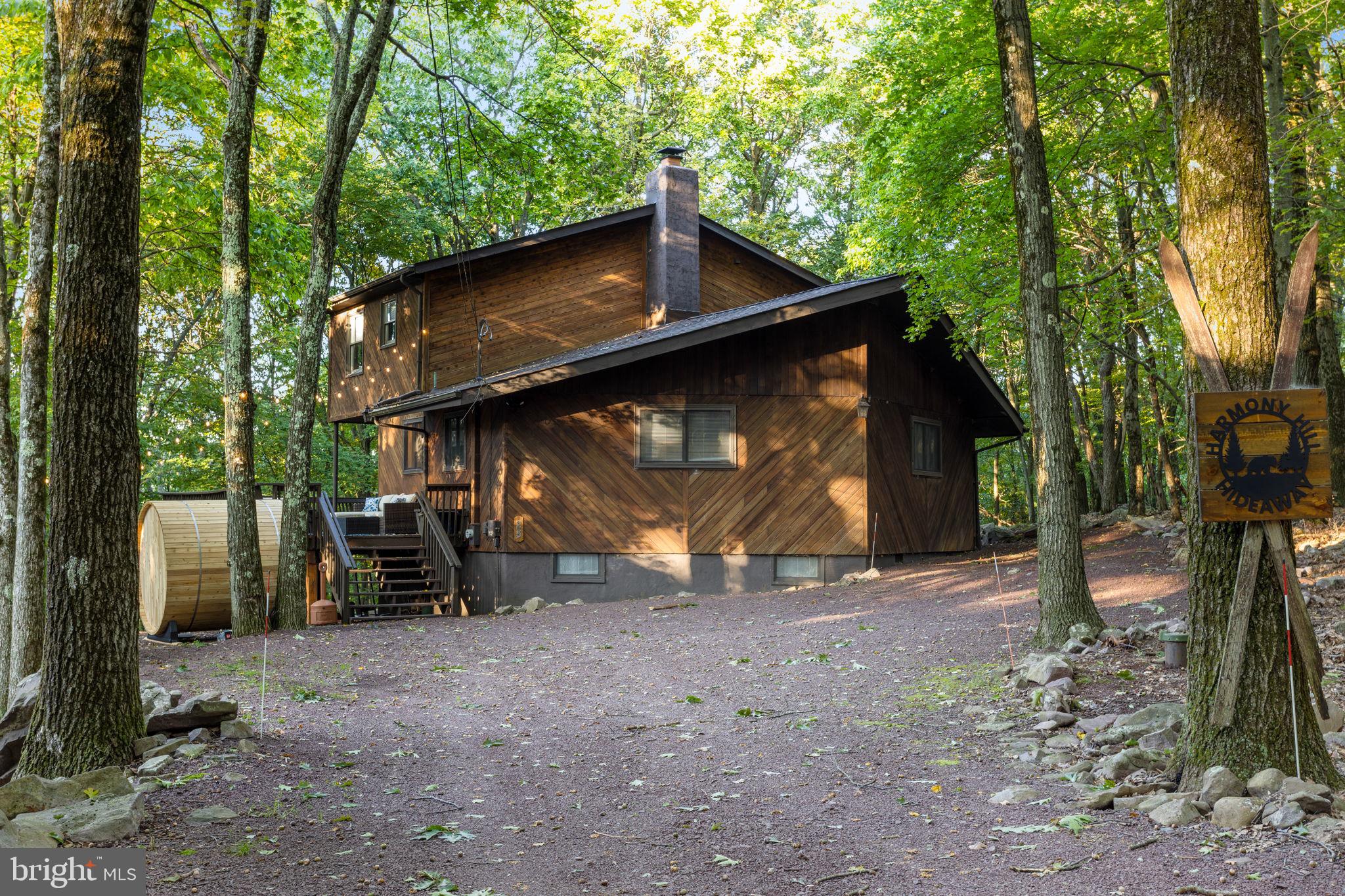 Four Seasons of Fabulous! All your heart's desire in this 4BR 2Bath Lake Harmony Estates contemporary woodland chalet. Enjoy all of nature seated on the large wrap around deck, a hot tub soak, sauna or just relax fireside. Cozy up in the family room w/a wood burning fire, gather together & create your memories in this home designed for style, comfort & entertaining! Amenity filled & STR friendly community. Hike, bike, ski, fish, boat and so much more.  Lake Harmony is calling-I've got the key!