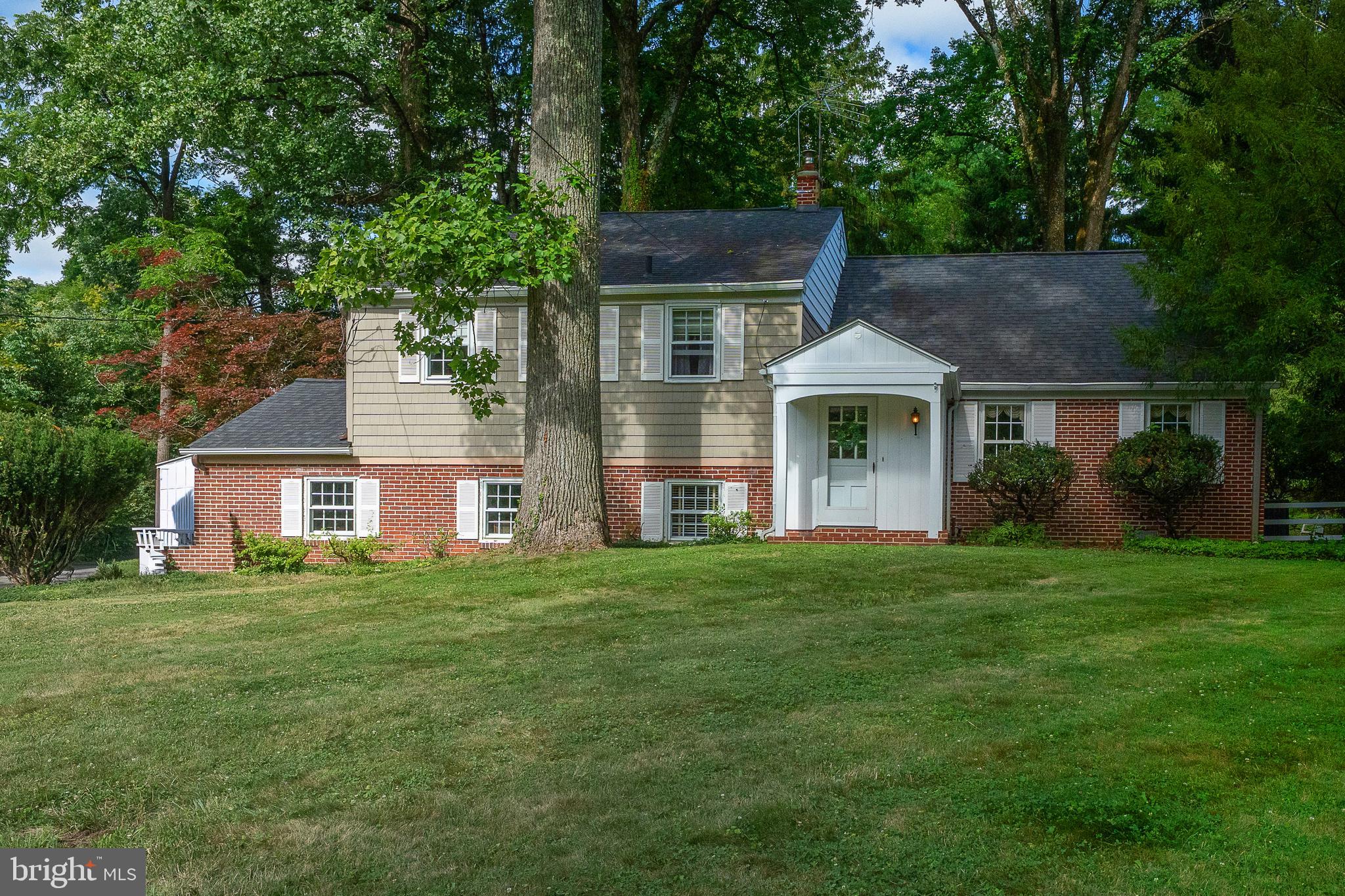 Quaint brick split-level style colonial farmhouse on a beautiful, wooded and nearly level one+ acre parcel. House has attached, two car garage, small shed and a pool, two fireplaces, central air and great privacy.  Front walk approach to front door vestibule. Enter spacious, formal living room with large, sunny windows and brick fireplace with built-ins.  Living room opens to formal dining room, which also has large, picture windows of the splendid lot and grounds.  Dining room opens to eat-in kitchen, with picture window over sink with view of bright and sunny private, brick patio at the rear. Kitchen has wall oven, and a built-in desk hutch. Kitchen also opens to foyer for great flow.

Kitchen stairs down to lower level and garage. Lower level has powder room, coat closet, laundry and mechanicals room. Large bright family room with cozy brick fireplace, sunny windows and a small, rear glass atrium / sitting / mud room at back door.

Main floor foyer has stairs up to second level. Second floor has three bedrooms and two full bathrooms.  Spacious owners' bedroom has pretty hardwood floors and bright windows, full dual closets with en suite full bathroom . Two family bedrooms share the full hall bathroom, with shower over tub.  Upper level has additional, third family bedroom.  Stairs up to partially-floored, unfinished attic.