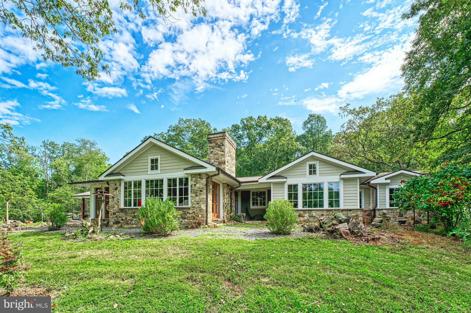 Just north of the Town of Leesburg, this renovated Craftsman sits on more than 40 acres across two parcels, surrounded by open pasture, seasonal mountain views, and easy access to Loudoun County’s well-known wineries, breweries, and gathering spots. Thoughtfully expanded for true one-level living, the main floor is filled with character-rich details, including salvaged architectural doors, paneling, and trim.

The gourmet kitchen features warm wood floors, a six-burner gas stove, and a custom island crafted from wood taken from the property’s original log cabin. A substantial addition created a private main-level primary suite with a beautifully finished bath, walk-in closet, and its own laundry. Two additional bedrooms—one with an en-suite bath—offer comfortable accommodations, and a dedicated office with a large closet could easily serve as a fourth bedroom.

The family room and adjoining dining area both feature heated stone floors, walls of windows, and French doors that open directly to outdoor living spaces.

The property also includes a historic log house that was original to the land. Relocated to its current site, it now offers two bedrooms, a full bath, and its own kitchen—ideal for guests, extended family, or possible rental use—while still showcasing vaulted ceilings, a stone fireplace, and beautiful floors. 

Equestrian amenities include an 11-stall barn with an extra-wide center aisle, a spacious tack room with a powder room, a dog wash station, and a heated and cooled gathering room. Approximately 15 acres are fenced and complemented by run-in sheds and a pond.

Zoned AR-1 with no easements, this is a rare opportunity to own a versatile country property that blends history, comfort, and wide-open space just minutes from Leesburg.