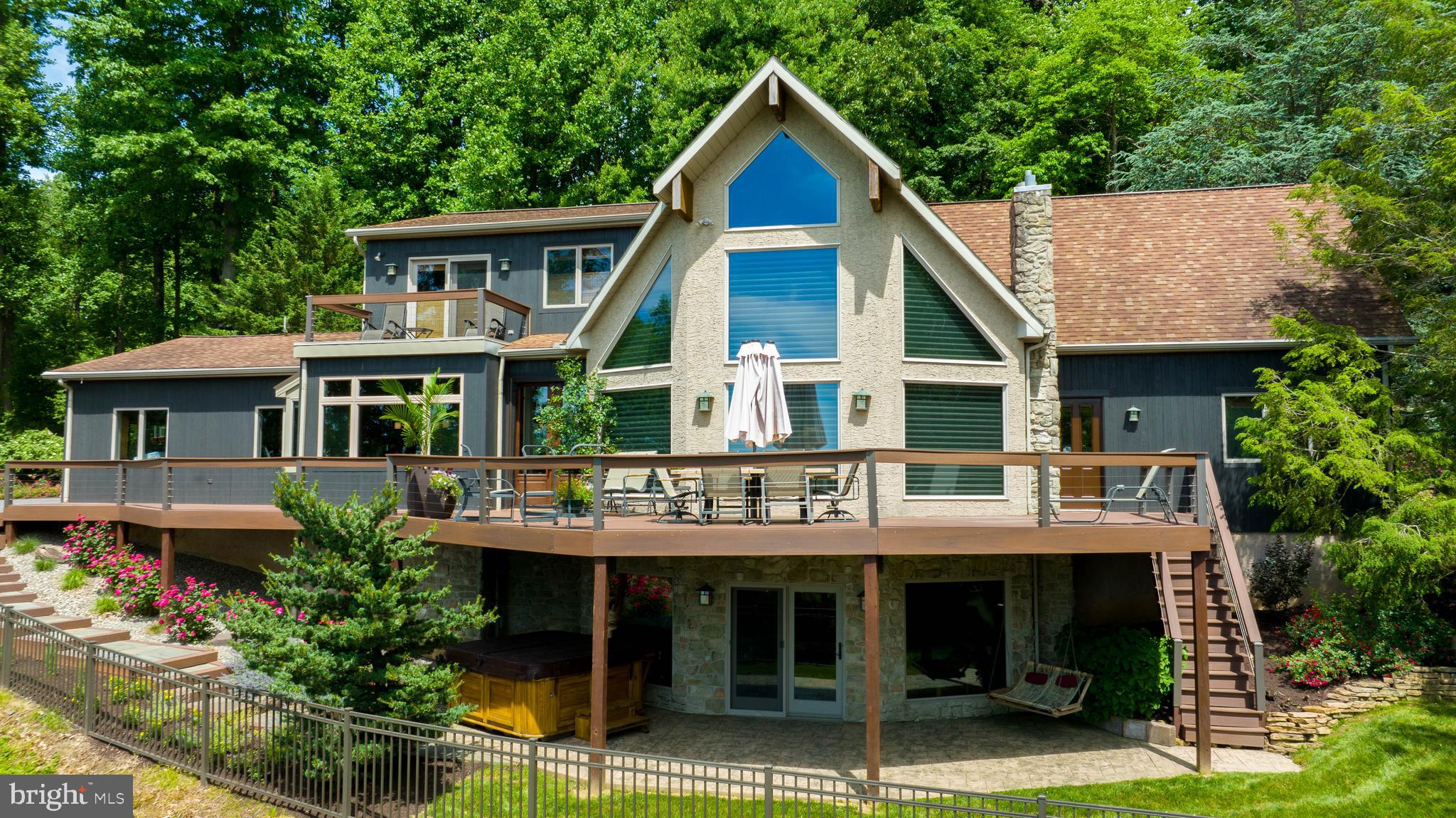 Welcome to your dream house! Privately situated on a wooded 3.1-acre lot overlooking farmland with south-west exposure and million-dollar views, this 5,000+ square foot home has a bright and beautiful open floor plan that includes 5 bedrooms, 4.5 bathrooms and finished daylight basement with wet bar. From the moment you step inside you will enjoy all of the fine details and unique style that the home has to offer. Gourmet eat-in kitchen with built in bench dining area consists of island, water filler over gas range and wall oven, beautiful tile backsplash above the granite counters, and ample cabinet space. Dining room (with roughed in plumbing for possible bar) opens up to a patio – perfect for entertaining. Additionally, the home features a 2-story family room, tray ceilings, hardwood flooring, surround sound throughout, Jenn Air pro appliances, central vac with 2 dust pans, and radiant heated floors in primary bathroom, kitchen, laundry and powder room. Primary bedroom suite features a private balcony, spacious bathroom with dual sinks, supplementary vanity space, soaking tub and glass tile shower. Additional second floor bedroom attaches to loft area, and there is also potential for in-law quarters. Enjoy the professionally landscaped lawn from the wraparound deck on the front side of the home, and the rear oversized patio with waterfall, built-in grill, and plenty of space for outdoor dining and relaxation.