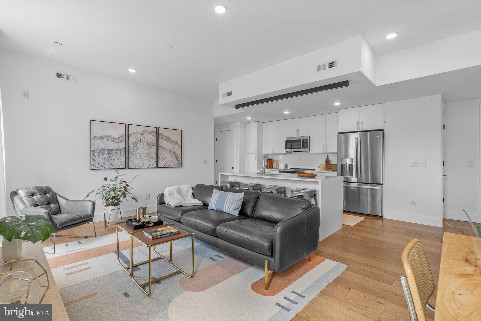 Welcome to Otto on the Park, a sophisticated collection of contemporary condos offering the convenience of parking and more. Enjoy a tax abatement through 2032! Amidst a burgeoning neighborhood, this unit boasts a private balcony and private roof deck, as well as access to the shared roof deck with breathtaking skyline views, PLUS one car deeded parking! The open floor plan features hardwood floors, soaring ceilings, and abundant natural light throughout. The spacious living area includes large windows, recessed lighting, and ample space for an entertainment setup. A dining area with balcony access compliments the chef-style kitchen equipped with white cabinetry, a generously sized island with breakfast bar, subway tile backsplash, and stainless steel appliances. The unit offers two well-appointed bedrooms with ample closet space. Both graciously sized bathrooms are elegantly designed with beautiful finishes. Additional highlights include in-unit laundry facilities and convenient storage space. Residents can enjoy a communal roof deck featuring a kitchenette, grill, skyline panoramas, dog run, and room for gatherings. Nearby amenities include Revival Brothers Coffee across the street, as well as proximity to Fairmount attractions such as the Schuylkill River Trail, Boathouse Row, and the Philadelphia Zoo. Taxes & square footage are the buyer's responsibility to verify independently. The PAR Standard Agreement of Sale for New Construction must be used for new construction properties, whether completed or not.