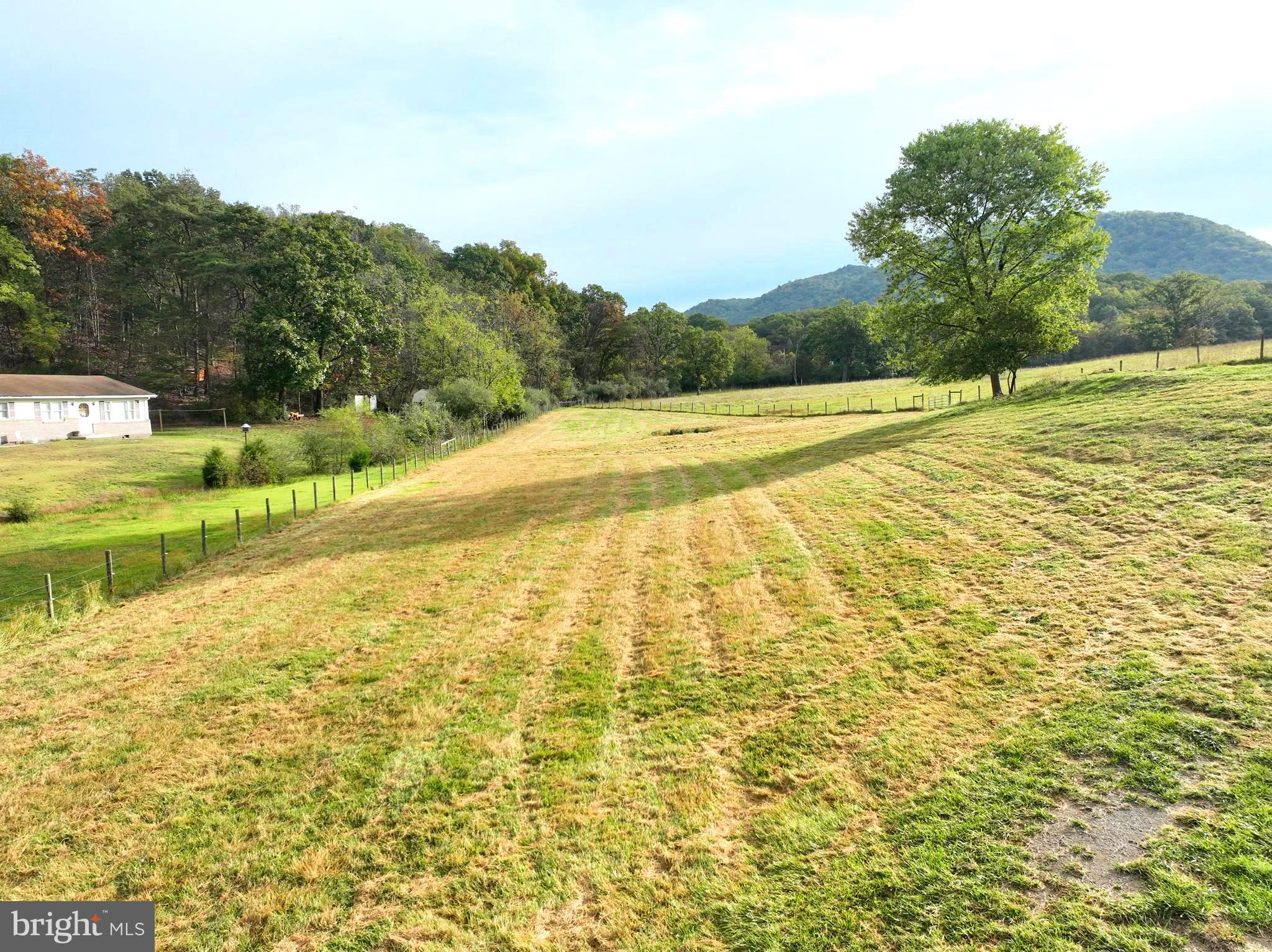 Escape to the open countryside and make this 1.50-acre parcel near the Hampshire–Hardy County line your own. Perfectly situated just off U.S. Route 220, this property offers the best of both worlds — peaceful rural living with quick access to modern conveniences. You can be in Moorefield in minutes or reach the I-81 corridor near Winchester, Virginia, in just over an hour via Corridor H. The land is 100% open and fully usable, mostly fenced for livestock, and features a small pond framed by big mountain views. Public water and electricity are available along the access road, and the owner reports a 3-bedroom septic system is already in place. With no restrictions, you’ll have the freedom to build, farm, or simply relax and enjoy your own wide-open space in the country.