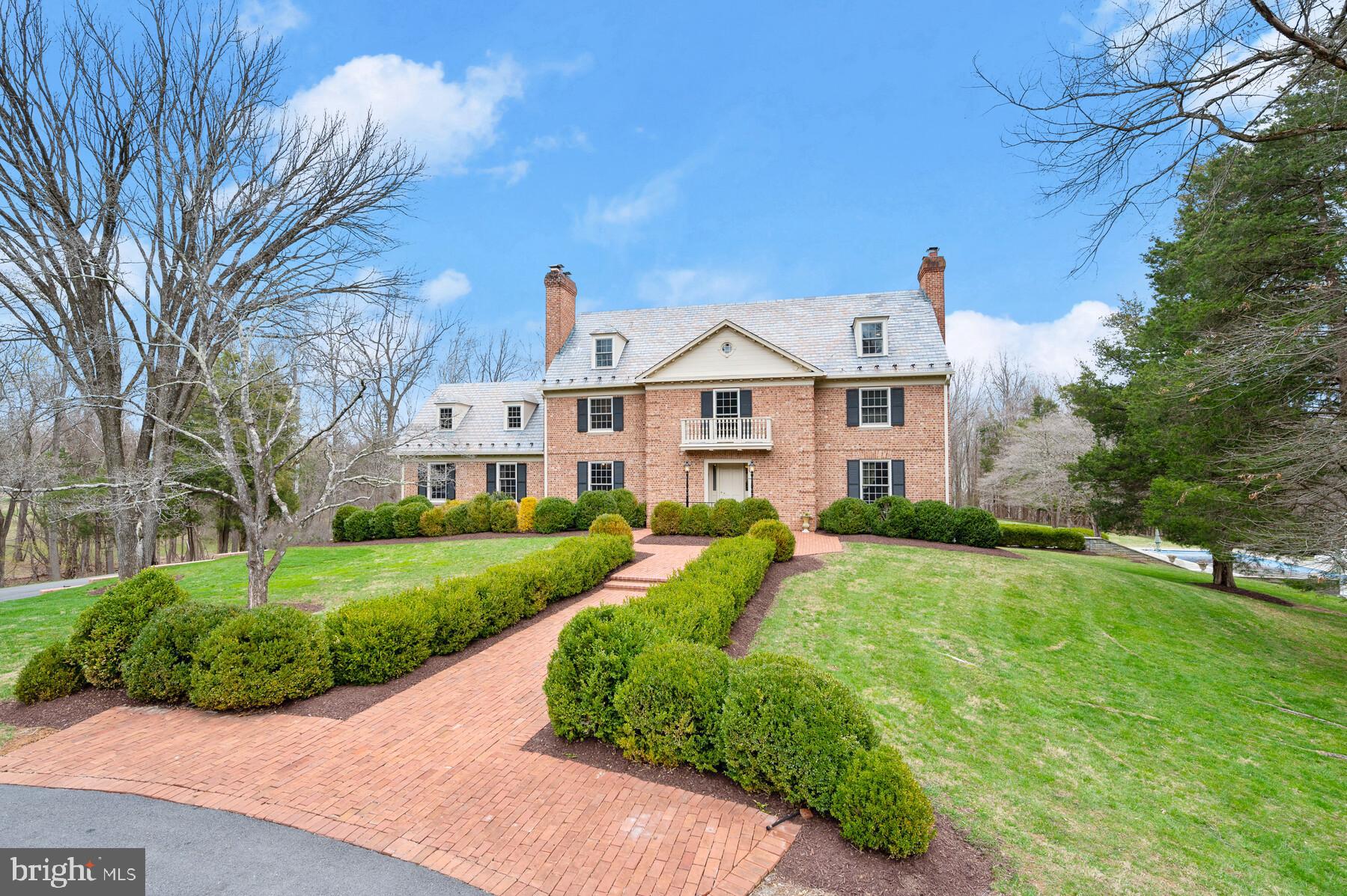 It's hard to know where to start with this truly special home.  Designed by the well-known local architect, Will Worland and constructed by the renowned builder, Patrick Cullinane,  this home has so many wonderful features it's hard to list them all.  Let's start with Deakins Lane, a quiet, bucolic country road with a real sense of community where neighbors know and care for each other.  This home, built in 1965 on just under 12 acres, must have been one of the Cullinane family's early builds.  It has all the trademark Cullinane features - exquisite brick work, the classic Williamsburg colonial styling,  a slate roof, symmetrical double chimneys, wide pegged plank flooring, numerous fireplaces (6!!) and exceptional moldings throughout - crown, chair, wainscoting, picture moldings plus a heavy, colonial brass door lock with the antique style key.   Cullinane homes have long been coveted due to the quality of the construction and the fine finishes.  Along with the  classic Cullinane details, this home is solidly constructed with oversized windows, a slate roof , main and upper level family rooms and multiple front and back staircases with deep stair treads, all a very costly expense for a builder.   The floor plan with almost 9,000 square feet is wonderful with spacious rooms on four finished levels, a terrific back porch for entertaining and a bedroom balcony when you just need to get away from it all.  

Along with the spectacular home, you will love the magnificent grounds including the Cypress tree lined drive, a circular drive and a grassy backyard that goes on forever.  Lacrosse, soccer, football - just name it and there's space to play!   The setting surrounded by woods offers incredible privacy.   In addition to the main house, these Owners constructed a Georgian style, all brick pool house with a high tray ceiling "Family Room", a kitchenette, changing room and "His" and "Her" full baths plus a separate laundry.   The heated plaster pool with flagstone decking and stone retaining walls will be popular all summer long and into the early fall.  Call your family and friends...the party is here!!   There is plenty of room for entertaining!  But don't miss one of the really unique features of this home--the pond!   Stocked with bass and blue gill, the landlocked pond with two natural springs is shared by five neighbors who enjoy fishing, swimming and small boating.  It's your own piece of paradise! This home is an absolute treasure and an easy place to call home.  Why not make it yours today?

See the virtual tour link for more detailed information.  NOTE: 2 lower level full baths are in the pool house.