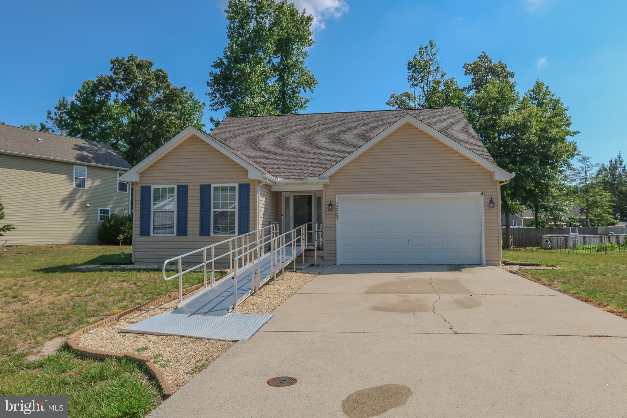 Enjoy easy one-level living in this 3-bedroom, 2-bathroom home located just outside the Town of Georgetown with public sewer service. The open floor plan creates a welcoming flow between the living room, dining area, and kitchen, making it ideal for everyday living and entertaining. The kitchen features an island with seating, pantry, and stainless steel appliances. A sliding glass door off the dining area leads to the backyard, providing easy access to outdoor space. The primary suite offers a walk-in closet and private bathroom with a dual sink vanity and tub/shower combination. Two additional bedrooms share a full bathroom, providing plenty of room for family, guests, or a home office. A utility room is conveniently located just off the kitchen, and the attached 2-car garage provides additional storage and parking. A ramp leading to the front entrance adds accessibility and convenience. Don't miss this opportunity to own a well-maintained home in a desirable Georgetown location.