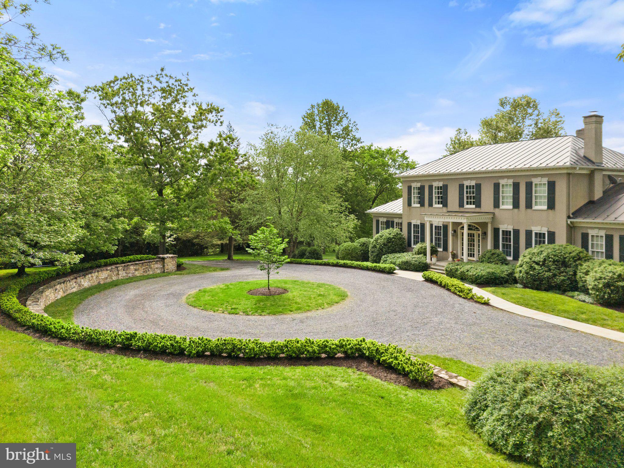 Welcome to this elegant Georgian manor home on twenty plus landscaped acres with Goose Creek frontage and mountain views in Middleburg.  The thoughtful floor plan is perfect for entertaining and family living. The 8,000 + square feet cover 3 levels and showcase quality finishes and architectural details. There are four bedrooms (two primary suites, one on the main level) all with en suite bathrooms and large closets.  The main level primary suite includes a large walk in closet with built ins and large bathroom offering dual sink vanities with marble countertops, separate soaking tub and large shower. The marble floors are heated. 
The main level of the home is open and airy with large windows and doors throughout to take in the garden views. The main level includes a formal living and dining room; home office with built in bookcases; gourmet kitchen with Sub zero and Wolf appliances; breakfast nook and walk in pantry; there are two family rooms both with fireplaces and tv room/ bar with built in refrigerator and wet bar. A large laundry room with built in storage is off of the kitchen.  
The lower level offers an abundance of space and a multitude of options for your living needs and personal style. There is a full gym with rubber flooring, a conditioned wine closet, a full bathroom, mechanical room and three large carpeted rooms for your specific use. There is abundant storage on this level. The attached two car garage is accessed here and includes a separate stairway from inside of the garage up to the laundry room next to the kitchen. The garage has a separate mechanical room and more built in storage. 
Mature landscaping and large trees enhance the home. There are multi-level formal gardens with specimen crepe myrtle trees, raised garden beds and multiple seating areas for entertaining and enjoying the out of doors. 
A large pasture is at the back of the home and offers ample space for horses or other livestock. A run in shed and large equipment building are available. The property is in Middleburg Hunt territory. The pasture is surrounded by woods and bordered by Goose Creek.  The adjacent landing to Goose Creek offers easy access to launch your kayak or just sit and fish. 
This quality property is truly one of a kind and is not to be missed.
