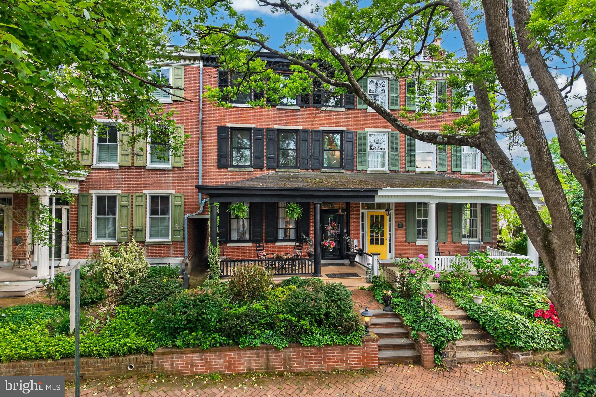 Welcome to  historic 340 W Miner St in the Portico Row section of the Borough of West Chester, characterized by elite history and architecture.  Homes in this desirable section of town do not become available often.  Timeless elegance and modern comfort come together beautifully in this 3,020 square foot townhome, just across the street from historic Mechanics Row. Built in 1848, this home is within walking distance to the center of town, with its myriad shops and restaurants. A new two car garage (with living/office space above) provides coveted off street parking! This home boasts 6 bedrooms, 3 full and 2 half bathrooms. As you enter from the quaint front porch, you are greeted by rich wood floors, that flow seamlessly throughout. Along the entryway is a built in hall tree, and just further down, on opposite sides of the hall are a half bath and the formal Living Room with a fireplace. Continue through to the spacious dining room with chestnut wood floors, followed by the heart of the home, the eat in kitchen, with slate countertops, shaker cabinets, stainless steel appliances, a large island, recessed lights and wide plank hardwood floors. Just outside the kitchen is a wet bar area with a brick wall backdrop, in addition to a half bathroom and storage/mud room.  On the 2nd level you’ll find the spacious primary bedroom suite. The large primary bathroom retreat has a clawfoot soaking tub, luxurious glass shower stall, and double sink. This level has two additional bedrooms and full bathrooms, along with the laundry room. Continuing up to the 3rd level are the final 3 bedrooms. All 6 bedrooms have their own entrance doors. Out back is a charming stone patio area with room to grill and share a meal, or simply relax and unwind. At the back of the yard is the impressive garage with ample space for 2 cars. A black spiral staircase takes you to a cozy 2nd floor that would be perfect for an at home office, home gym, or living area. It features a large room with a kitchenette and a full bathroom. Multiple windows allow for lots of natural light. 340 W Miner St can truly set the stage for a comfortable lifestyle, memorable gatherings and easy access to local amenities, parks, shops and dining options. This rare find combines both historic character and modern conveniences you’ll truly appreciate. This is your chance to own a piece of West Chester history!