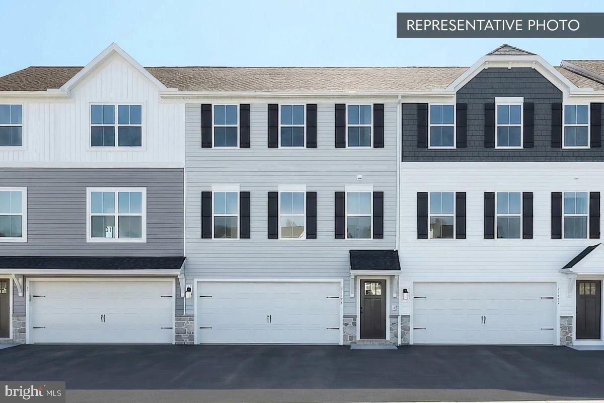 Homesite 214 at Logan Greene is a Barberry end-unit townhouse by Berks Homes with a design package that hits the right notes throughout. Currently under construction with an estimated completion of October 2026 (estimated — subject to change), this Quick Move-In home is finished, decided, and ready for the next chapter — no Selection Gallery visits required.
The kitchen sets the tone from the start: an island layout with quartz countertops, tile backsplash, upgraded cabinetry and hardware, gas stainless steel appliances, and pendant lighting above the island. Recessed lights keep the kitchen bright and open, while four more fill the family room with the same warm, dialed-in ambiance. Upgraded EVP flooring flows through the main living areas, grounding the space with a polished, low-maintenance finish.
Upstairs, the primary suite offers two walk-in closets and a bath designed with intention — raised vanity, quartz vanity top, double bowl sink, upgraded fixtures, and a semi-frameless sliding shower door opening to a 60" tiled shower complete with a built-in seat and recessed niche. The hall bath holds its own with a quartz vanity top and upgraded finishes, and all three bedrooms are well-sized with easy access to the upper-level laundry.
Outside, a 10' × 10' composite Azek deck with steps to grade extends the living space into the fresh air, while stone-to-sill detailing on the front elevation makes a strong first impression. A 2-car garage with LiftMaster opener and keyless entry keypad, 2-tone interior paint, and a 10-year warranty round out this move-in-ready townhouse.
Taxes based on completed home. Subdivision assessment pending. Photos may include options or upgrades not reflected in list price and may be virtually staged or digitally enhanced.