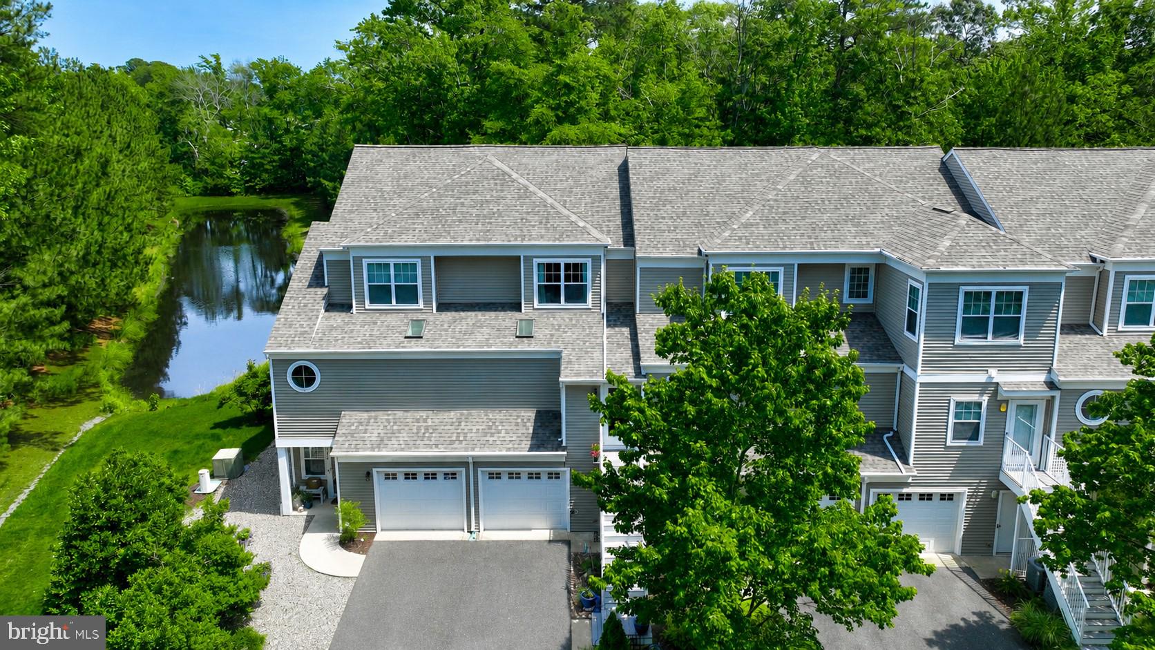 Welcome to 37508 River Birch Lane, a beautifully maintained three-story townhome tucked away in the established community of Windmill Woods in Ocean View, Delaware. Perfectly situated on a private lot backing to mature trees overlooking a serene pond, this exceptional home offers the ideal blend of comfort, style, and natural beauty.

A charming flagstone pathway leads through the backyard and into the wooded area beyond, creating a peaceful setting rarely found in townhome living. The elevated rear deck provides the perfect perch for morning coffee, afternoon birdwatching, or evening cocktails while enjoying the  tranquil pond and woodland views. 

Inside, the main living level is warm and inviting, featuring rich hardwood floors, crown molding, and an open-concept layout designed for both everyday living and entertaining. The beautifully appointed kitchen showcases warm wood Craftsman-style cabinetry with under-cabinet lighting, granite countertops, a stylish tin backsplash, ceramic tile flooring, and newer stainless-steel appliances, all replaced within the past two years except for the dishwasher. The adjoining dining area flows seamlessly into the spacious living room, highlighted by a cozy gas fireplace. Just beyond, the sunroom offers additional living space complete with a wet bar, making it the perfect spot for gatherings or quiet relaxation.

The upper-level features two generously sized bedrooms, each with its own private ensuite bath, providing comfort and privacy for family members or guests.

The first-floor level offers exceptional flexibility and privacy, featuring its own exterior entrance, making it ideal for guests, extended family, or a private retreat. Complete with a spacious bedroom suite, wet bar with beverage refrigerator, luxurious bath, and access to the covered, gated patio, this highly desirable setup provides a variety of lifestyle options.  The owner has enjoyed substantial rental income from this private first-floor space, offering an attractive opportunity for those seeking supplemental income while maintaining the comfort and functionality of a single-family residence.

Additional features include a spacious one-and-a-half-car garage, providing valuable extra storage space for beach gear, bicycles, tools, or a workshop area. An additional refrigerator located in the garage will convey with the home. 

Practical upgrades include an irrigation system to help maintain the landscaping, as well as a security system for added peace of mind.  Major updates have already been completed, including a new roof installed in 2025, one HVAC system replaced in 2021, and a newer washer and dryer. 

With its unique floor plan, thoughtful upgrades, exceptional outdoor spaces, and picturesque setting, this one-of-a-kind home offers a rare opportunity to enjoy coastal Delaware living at its finest.