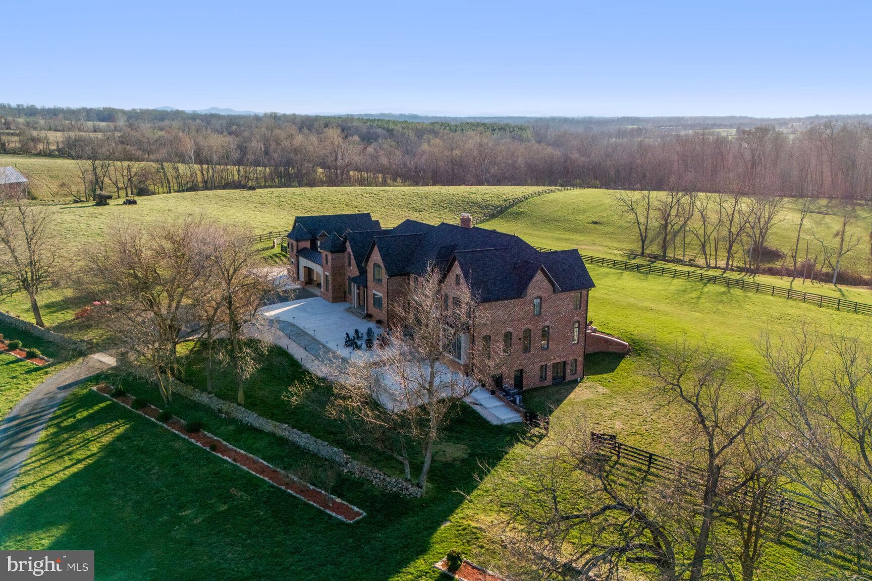 Welcome to Belvedere, where luxury meets tranquility in the heart of the Middleburg Hunt countryside, overlooking the majestic Blue Ridge Mountains. This magnificent gated estate sprawls across 27 acres of ultra-private oasis, offering unparalleled privacy and breathtaking views.

Nestled atop a hill, the grand colonial main home spans over 9000 square feet of meticulously finished space, showcasing timeless elegance and exquisite craftsmanship. Designed by James MacDonald of the esteemed Lessard Group and constructed by University Homes, this home has garnered accolades for its impeccable architecture and construction, including awards from Home and Design magazine.

As you enter through the new stone pillars flanking the sweeping paved driveway, lined with black fencing, you're greeted by the splendor of this estate. Extensive renovations have recently transformed every corner, with fresh paint adorning both the interior and exterior, and newly refinished Brazilian cherry hardwood floors adding a touch of warmth to the main level.

The gourmet chef's kitchen is a masterpiece, boasting Cambria quartz countertops, new tile backsplash, and top-of-the-line Wolf appliances. The spacious great room and dining area overlook the expansive backyard, perfect for entertaining or simply enjoying the serene surroundings.

Upstairs, the luxurious Owner's Suite has been completely remodeled to perfection, offering a sanctuary of comfort and style. Step onto the idyllic screened porch to savor panoramic views of the manicured backyard with mature landscaping and a charming pergola.

For guests seeking privacy, the attached carriage house provides a retreat of its own, complete with a full kitchen, living area, and bedroom suite. With a covered breezeway connecting to the main house, convenience meets elegance in every detail.

Outside, the property has been meticulously landscaped, with newly added perimeter fencing and cross-fencing enclosing the lush pastures. A front patio, built in 2022, offers a serene spot to soak in the surroundings.

Despite its secluded location, Belvedere is just minutes away from the charming downtown of Middleburg, offering a wealth of shops, restaurants, and cultural attractions. Whether you are unwinding in the comfort of your luxurious home or exploring the beauty of the surrounding countryside, this estate is truly designed for those who demand the very best in life.