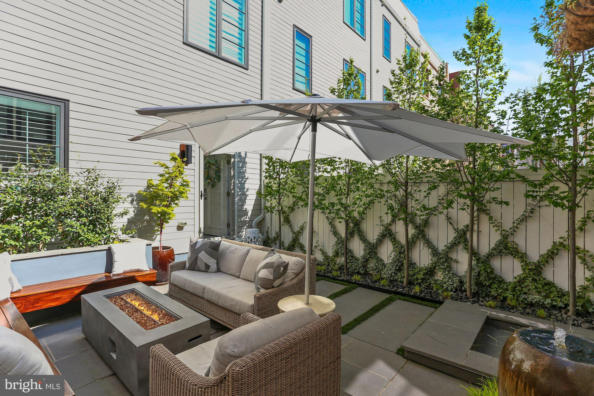 ** Furnishings Sold separately  ** This stunning modern masterpiece, is like no other in Potomac Yard and all furnishings will convey for the right offer in this impressive turn key home! Smart home enhancements w/Control4 Home automation system operated by Alexa (use commands posted throughout home for full interactive experience!).  10 & 9' ceilings , surround sound,  4th level theater room with rooftop deck terrace, double-sided fireplace, outdoor  speakers & outdoor wall mounted TV!  The 2-car garage has an abundance of built in storage, but can also double as a great space to watch sports games with the neighbors on the flat screen TV! Above the garage you will find a studio living space that offers wet bar, beverage cooler, full bathroom, with in home gym already set up! The impressive courtyard is nestled between the 4 level townhome and the carriage house that is sure to impress!! Meticulously designed by landscape architects, this outdoor oasis offers hardline gas fire feature centered amongst the built-in bench seating, surrounded by winter blooming landscape, with calming water fountain and recirculation system, European Hawthorne trees adorn the fence providing grandeur privacy year-round, with enhancement lighting built in throughout to showcase every inch of this sophisticated entertainment space day or night!   The main level is nothing less than dazzling with open floor plan that flows seamlessly into the gourmet kitchen w/customized pantry, under/above cabinet lighting, wrap around cabinets, oversized island w/bar seating for casual dining. Head upstairs to the 2nd level to find the oversized primary bedroom boasting 2 balconies, plantation shutters, and a custom designed wardrobe dressing room with glass doors to pave the way for more natural sunlight to more easily shine into your spa like en-suite!  Across from the primary bedroom is a bedroom that can double as a home office or nursery with custom remote-controlled shades! On the 3rd floor you’ll find the laundry room and full bathroom conveniently centered between two more bedrooms and the fully renovated, and enclosed sun-drenched family room w/wet bar and 2nd in home office/entertainment space! Finally the 4th floor rec room is fully equipped for movie night with built in 4k projector, 110” backlit screen, wet bar, surround sound, and popcorn machine! A true rare find with over $300k in exceptional upgrades at every turn! Not only will this fully furnished home be one of the easiest moves you’ve ever had, but it will also be the best investment you’ve made in your lifetime! Potomac Yard is considered one of the best places to live in the DC Metro area because it affords the neighborhood feel, while being centered amongst walkable dining/shopping/coffee shops/parks, a mere 7-10 min drive to Old Town Alexandria and Reagan National Airport, but yet another driving factor to why so many flock to this neighborhood is for the investment opportunity! Amazon HQ2 construction is well underway, located less than 2 miles north of Potomac Yard, expecting to complete their two 22-story office buildings and 50,000 sq ft of retail space in 2023,  Potomac Yard Metro Station (Blue/Yellow line) should be finished by Summer 2023,  Virginia Tech’s Innovation campus on 3.5 acres adjacent to the Metrorail Station plans completion by Fall 2024,  and the community transformation morphing Potomac Yard, Crystal City and Pentagon City into the “National Landing” will soon to be Virginia’s largest walkable downtown blending the best of both city life and the great urban outdoors! Bring your essentials and start living your best life at 2106 Main Line Blvd! WELCOME HOME!