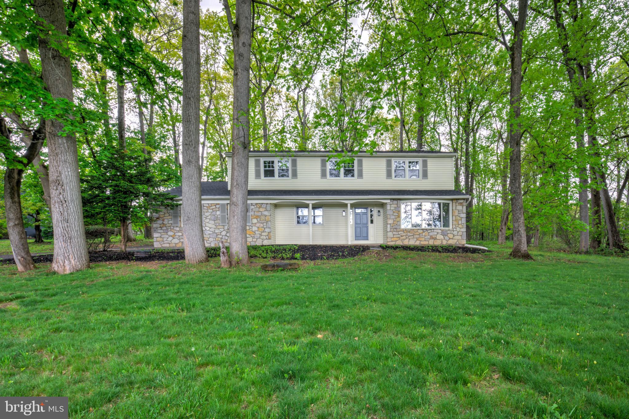 Welcome home to this completely renovated 4-bedroom, 2.5-bath single-family home with an attached two-car garage, ideally located in the highly sought-after Doylestown area. Set back from the road on a partially wooded lot, this property offers both privacy and a beautiful natural setting. Inside, you’ll find hardwood floors throughout and a spacious, flexible floorplan. The main level features a formal living room and an inviting open-concept family room with a stunning stone fireplace, seamlessly flowing into the brand-new kitchen. The kitchen showcases white cabinetry, quartz counters, tile backsplash, stainless steel appliances, and a large center island perfect for meal prep, casual dining, and entertaining. A convenient mudroom off the garage includes laundry and a powder room. Upstairs, three generously sized bedrooms share a full hall bathroom with a tiled tub/shower combination and oversized vanity, while the desirable primary suite offers a spacious retreat with walk-in closet and private bathroom complete with double vanity and walk-in shower. The lower level provides a clean, open basement for practical storage or future finishing potential. Additional updates include a new architectural shingle roof, brand new efficient HVAC, and a passing septic inspection for peace of mind. This turnkey property combines modern updates with timeless style in a serene, natural setting—schedule a showing today!