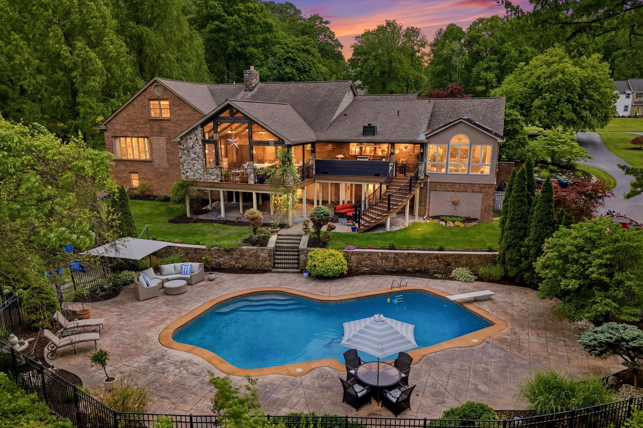Offer Deadline of Sunday night May 31st, with a respond by of June 1st please.  Saturday Open House extended to 3pm.  Sunday open house cancelled.  Buyers prefer a late August or September settlement if possible.  Nestled on two lots totaling 2.5 picturesque acres in the award-winning Downingtown Area School District, this extraordinary Bernie Hankin original custom residence offers approximately 5300 square feet above grade square feet!  Plus, it has approximately 2,200 additional finished square feet in the walk-out lower level!   This home sits at the end of a cul-de-sac so you can be assured it will always be quiet.  The circular driveway, professional landscaping with low-voltage lighting, and a stunning fieldstone and brick façade create unforgettable curb appeal, while breathtaking panoramic views extend for miles from nearly every angle of the home.

Designed for both luxurious everyday living and exceptional entertaining, the outdoor oasis features an 840 sq ft concrete in-ground pool with dimmable lighting, stamped concrete surround, aluminum fencing, secluded fire-pit area, greenhouse, and fenced raised gardens. The spectacular heated covered deck—complete with full outdoor kitchen, propane grill, stone fireplace, heaters, built-in speakers, and included outdoor TV—creates the ultimate year-round gathering space.  This outdoor living space with its curved staircase was one of Keystone Builders showcase designs for many years.  

The travertine paver walkway leads you to a covered porch and a beautiful double door entry.  The dramatic foyer with wood feature wall opens to a sunken living room featuring vaulted beamed ceilings, a striking two-story stone wood-burning fireplace, and an upper loft reading nook with built-in bookshelves. Crown molding, updated baseboards, hardwood and LVP flooring, stylish designer accent walls, and abundant natural light elevate every space.  The beautifully renovated kitchen opens seamlessly to the sitting room and showcases a massive 9.5-foot double island with quartz counters, induction range with hood, wine refrigerator, stainless steel appliances, built-in microwave, and custom finishes throughout. There is also a gorgeous sunroom with 6 skylights with miles of scenic views, as well as access to the outdoor living area. 

The main level includes two luxurious ensuite bedrooms, including an impressive primary suite with five closets—two being walk-ins and one as a dedicated shoe closet—and separate his-and-her bathrooms! The first spa-inspired bath includes a clawfoot tub, marble flooring, and custom marble tile work.  The second bath features a walk-in rainfall shower.  Additional main-level highlights include a private office with teak floors and custom built-ins, an oversized dining room with recessed lighting and crown molding, and a spacious mudroom/laundry room with walk-in pantry.

The fully finished walk-out basement is truly one-of-a-kind, offering multiple entertaining spaces including a theater area with 110-inch projection screen and subwoofers, social lounge, wine closet, propane stone fireplace, and an incredible two-tier wet bar with built-in cabinetry, wine fridge, ice machine, and kegerator. A premium $70,000 sound system with five Sonos zones provides immersive audio throughout. The lower level also includes a second seating area and a fully equipped mirrored gym with included fitness equipment.

Additional upgrades include multiple bathroom renovations, roof replacement (2015), newer Pella wood and vinyl clad windows, four heat pumps, three electrical panels, custom travertine front walkway (2021), fresh interior paint (2025), and recently renovated shared upper-level bath serving two spacious bedrooms with walk-in closets. This remarkable property seamlessly blends timeless craftsmanship, modern luxury, and resort-style amenities in one exceptional Exton setting.
