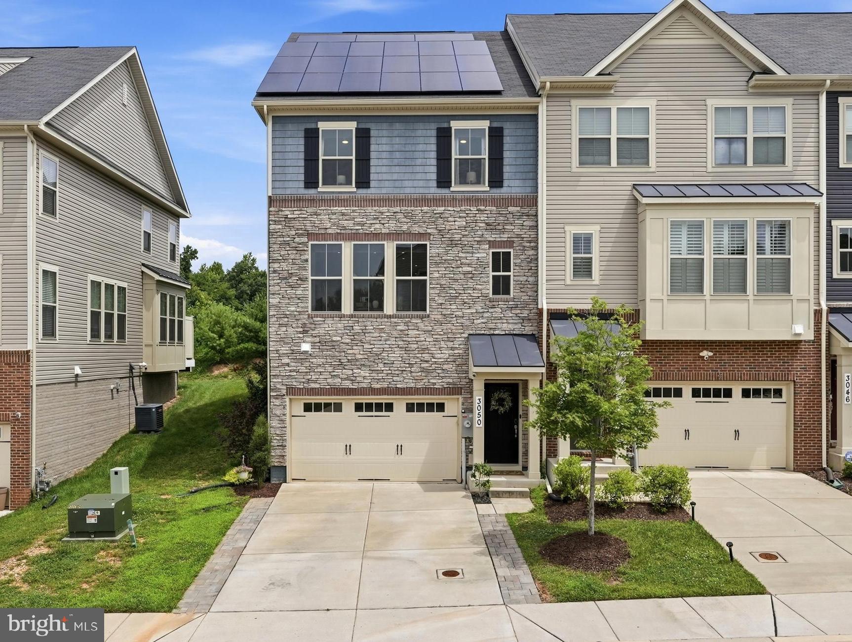 Welcome to this beautifully maintained end-unit townhome, built in 2020, offering modern finishes, abundant natural light, and the added value of fully-owned solar panels for energy savings. There is a 25 year parts and labor transferable warranty on the solar panels.  A charming covered front portico creates a warm first impression and invites you inside.

The main living level features a bright, open-concept design that's perfect for both everyday living and entertaining. Sunlight pours through the oversized windows, filling the spacious family room, dining area, and kitchen with natural light. At the heart of the home, the stunning kitchen showcases crisp white cabinetry, stainless steel appliances, quartz countertops, marble backsplash, a pantry, and an oversized center island with seating. The adjoining living area opens through sliding glass doors to a low-maintenance Trex deck, creating the perfect indoor-outdoor entertaining space. A convenient powder room, recessed lighting, and newer luxury laminate flooring throughout the main level complete this stylish space.

Upstairs, the spacious primary suite offers a walk-in closet and a private en-suite bath featuring a dual-sink vanity, walk-in shower with a built-in wraparound bench, and a separate water closet. Two additional generously sized bedrooms, a full hall bath, and a conveniently located laundry room complete the upper level.

The finished lower level provides even more flexible living space with a large recreation room featuring egress windows, a half bath, and interior access to the attached garage, complete with a 240V receptacle for electric vehicle charging.

Outside, enjoy a fully fenced, private backyard with play equipment, providing space to relax, play, or garden.

Residents enjoy exceptional community amenities, including an outdoor pool, fitness center, clubhouse, tot lots, playgrounds, and scenic walking and jogging trails. Combining modern construction, thoughtful upgrades, abundant natural light, and an unbeatable community lifestyle, this move-in-ready home is one you won't want to miss.