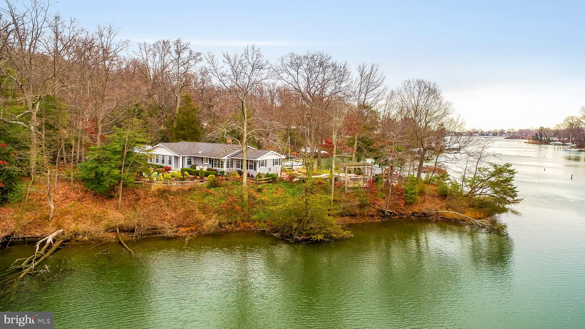 Panoramic water views with approx. 395 ft of water-frontage, heated waterfront pool, and easy access to your deep water protected pier! Elegant raised ranch sited on a well landscaped lot with waterfront patio.  Fabulous condition with over $150,000 in recent UPGRADES includes a gourmet kitchen with top of the line Viking and SS appliances, grand Master Bedroom/Bath suite, Private Office, and fully finished Lower Level.  High vaulted and cathedral ceilings, cozy wood burning fireplace, hardwood floors, and spectacular water views from most rooms!  Over 2860 Sq Feet of finished space.  Attached 2-Car Garage and ample parking to accommodate guests. Great for entertaining or intimate gatherings. Lovely community with amenities that include beach, boat ramp, common grounds, and picnic area.