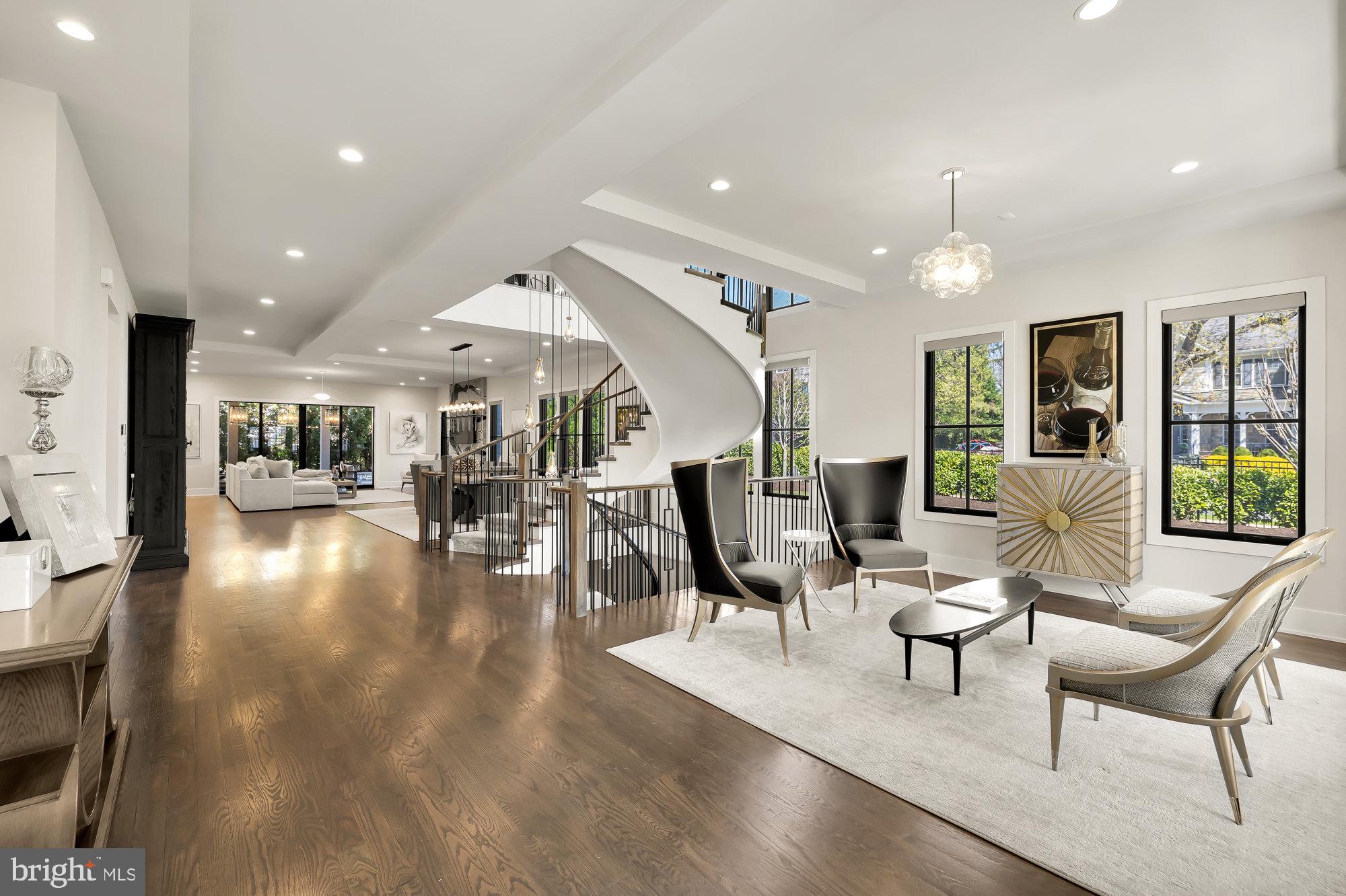 This 6 bedroom, 6.5 bath contemporary masterpiece has been thoughtfully reimagined with opulent finishes and modern amenities. Built in 2018 as the model home for the Retreat at Mclean community, the current owners improved it with a great number of luxury additions. Upon entry into this light-filled home your attention is drawn to one of its showpieces, a grand spiral staircase with a custom chandelier that suspends 28 feet over 3 floors. On this main level, the open floor plan combines the living, family, and dining rooms with a spectacular gourmet kitchen. The family room’s 12 foot glass pocket door wall opens completely to reveal a large covered patio, the epitome of indoor/outdoor living. The floor is completed by the adjacent Butler's pantry, wet mini bar, elevator access and laundry-mudroom. 

One level below contains a striking, custom wine bar with a temperature controlled 156 bottle glass enclosed cellar just opposite the den and open theater rooms with a 145" built in projection screen. A full gym features mirrors, a TV, and overhead fan. A bedroom, full bath, dual walk-in closets, and storage room comprise the remainder of this level of the home.

The second level contains 4 bedrooms and an office. The expansive Primary suite includes a sitting area, large walk-in closet, a luggage closet, spacious bath, and a covered balcony with large swinging daybeds. The other 3 en-suites each have walk-in closets and custom built-ins, with one bedroom including its own balcony. The office features a frameless glass enclosed home office which makes use of the light filled space and allows for noise reduction and privacy while keeping the open feel. A 2nd laundry room can additionally be found on this level easily accessible to all bedrooms.  

The top level Loft features a bedroom, full bath, a custom built in closet, a large entertainment room, a covered deck with an extended sunbathing area, an outdoor TV and a grill-ready gas line.

Additional features of this special home include:  elevator to all floors | designer wallpapers | custom light fixtures |  additional recessed lighting | custom tile | window treatments | ceiling treatments | Premium whole house air filtration system | 100 amp generator | two 75 gallon water heaters | Sonos sound system for interior & exterior | Custom Tigerwood kitchen island | Wolf range & SubZero refrigerator | 3 ovens and a warming drawer | Butler's pantry with an additional full sized refrigerator, sink, disposal & dishwasher | Touch Sensor Faucets | Wet mini bar w/ beverage center | Primary bath with dual vanities, dual shower heads, soaking tub, and heated floors | Motorized privacy shades in primary, all 1st floor windows, and basement | Custom garage with recessed lighting, thermostat heater, factory Tesla charger and suspended storage | Stacked stone window wells | Fenced yard with full irrigation system | Exterior security and landscape lighting | Exterior and Interior Security Cameras | Paver walkway from back to front | Alarm Security System.
