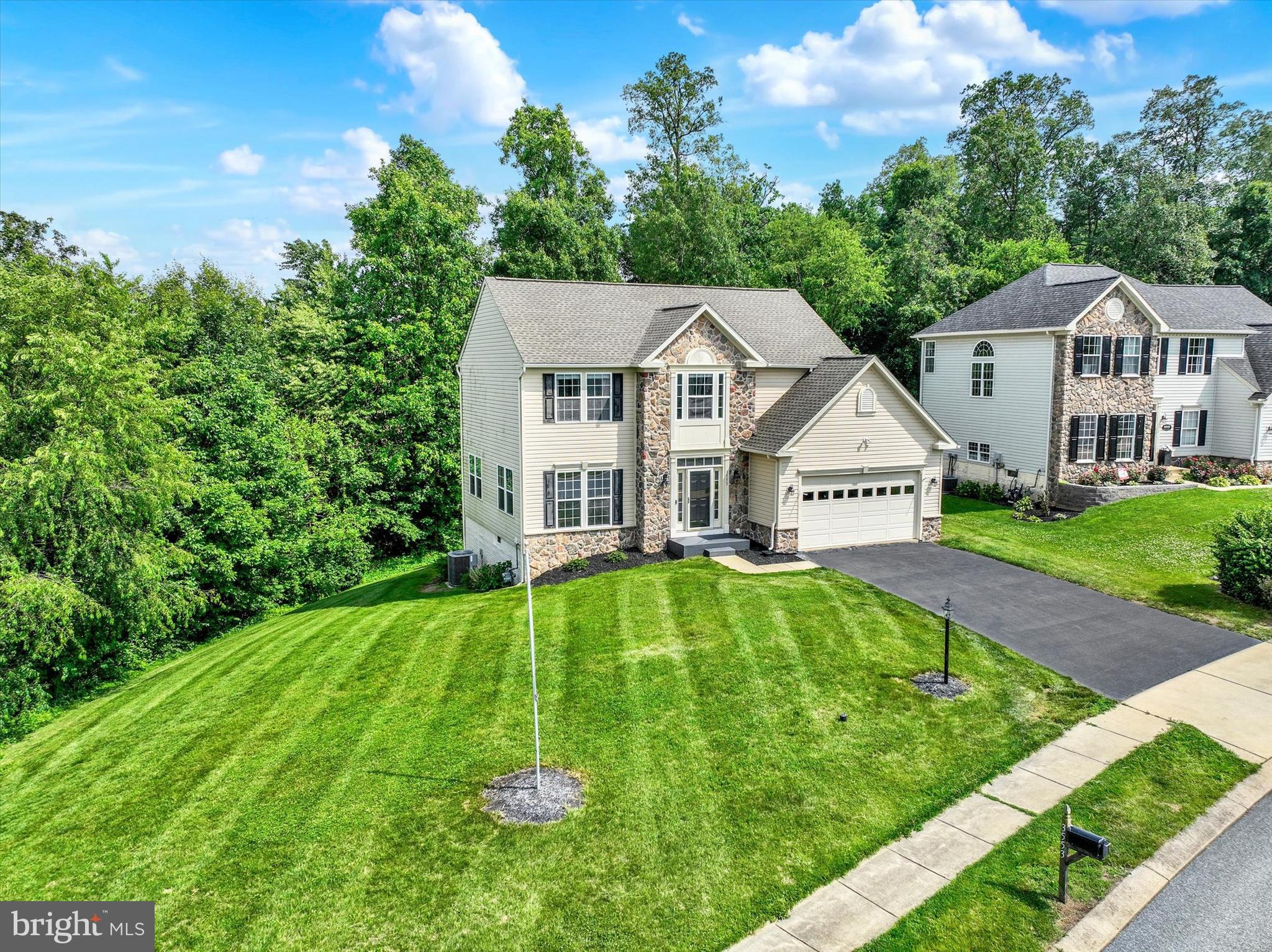 Welcome to 3553 Hardwood Terrace, an exceptionally maintained colonial with handsome stone accents, beautifully positioned on one of the most desirable premium lots in Codorus Estates. Tucked within the Southern York County School District and surrounded by scenic farmland, mature trees, and a private wooded backdrop, this remarkable property offers the rare combination of refined neighborhood living, peaceful country views, and everyday convenience. Just minutes from Codorus State Park, residents can enjoy hiking, boating, swimming, camping, and year-round outdoor recreation, while still being close to shopping, dining, and commuter routes.

From the moment you arrive, the setting feels distinguished. Meticulously maintained landscaping, calming views, and a premium lot create a sense of privacy and serenity that is difficult to duplicate within the community. Offering 4 bedrooms, 2.5 baths, 2,145 sq. ft. of finished living space, a 2-car garage, updated interior paint throughout, and a roof replaced in 2023, this home presents an exceptional opportunity to secure one of Codorus Estates’ standout properties. Thoughtfully cared for and beautifully presented, the home blends the charm of country living with a clean, contemporary style.

Inside, hardwood flooring, neutral finishes, generous natural light, and an open-concept design create an elevated yet comfortable atmosphere. The main level offers a welcoming foyer, formal living room, dining area, and a beautifully connected kitchen, sunroom/breakfast room, and family room layout designed for entertaining. The kitchen features white cabinetry, granite countertops, stainless steel appliances, recessed lighting, and a striking L-shaped granite center island that serves as the natural centerpiece of the home, ideal for preparing meals, gathering with guests, or enjoying a glass of wine at the end of the day.

The adjacent sunroom/breakfast room is bathed in natural light and offers a beautiful space for morning coffee, casual meals, quiet reading, or simply relaxing with peaceful views of the trees and landscape. Sliding glass doors open directly to the rear deck, creating a seamless indoor-outdoor connection perfect for holiday gatherings, summer grilling, weekend entertaining, or quiet evenings overlooking the private backyard. The adjoining family room is anchored by a fireplace, offering warmth and comfort while remaining open to the heart of the home.

Upstairs, the spacious primary suite provides a relaxing retreat with a large bedroom, walk-in closet, and private bath featuring a dual vanity, soaking tub, separate glass-enclosed shower, and tile surround. Three additional bedrooms and a full hall bath offer excellent flexibility for family, guests, office space, hobbies, or a nursery. The unfinished lower level provides valuable storage and future finishing potential.

Outdoor living is truly one of the defining features of this property. The elevated rear deck, covered gazebo/pergola area, firepit space, mature trees, farmland views, and beautifully maintained yard create a private outdoor retreat designed for both relaxation and connection. Imagine starting your Saturday morning with coffee in hand, birdsong in the background, and a front-row seat to the natural beauty and serenity this special setting provides. With its premium lot, 2023 roof, fresh interior updates, and highly desirable Codorus Estates location, 3553 Hardwood Terrace represents a compelling opportunity for buyers seeking privacy, scenery, comfort, and convenience in one unforgettable home.
