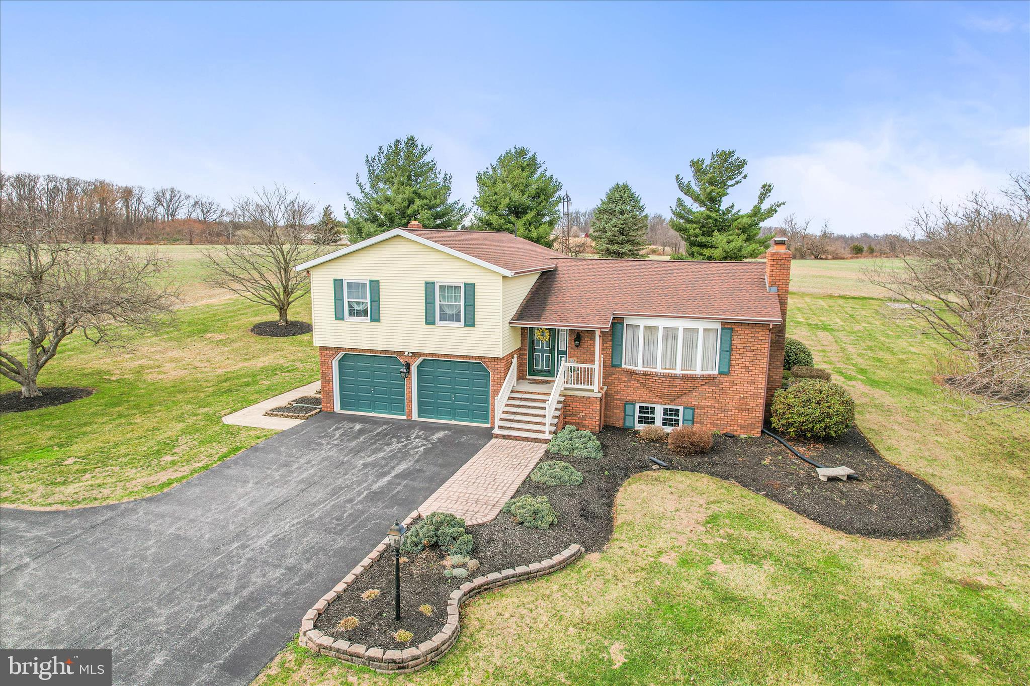 Huge price adjustment and freshly painted and other improvements currently taking place.  Don't miss out on this charming split-level home, built in 1981, offers a perfect blend of comfort and functionality, nestled on a generous 1.26-acre lot in a rural setting with unbelievable views. This home has been impeccably maintained over the years and shows through and through. The exterior features a classic brick facade complemented by well-maintained landscaping, a secure outbuilding offering 2 garage bays, and ample parking with both attached and detached garages. The cozy living room is enhanced by a beautiful brick fireplace and large lower level family room boasts a wood stove, perfect for those chilly evenings. This is great to offset heating costs too. Natural light pours in through the bay window, creating a bright and airy atmosphere throughout the home. 3 good size bedrooms and 2 full baths await you. Additional storage space can be found in the lower level and attic, while central air and ceiling fans ensure comfort year-round. Enjoy the outdoors from either your fire pit, expansive covered rear deck or front porch, ideal for morning coffee or evening relaxation. The property adjoins farmland,  offering panoramic views that enhance the sense of tranquility. This 1.26 acre cleared and level lot offers plenty of room for gardening or outdoor activities. Located just over the MD line from Littlestown Pa, this home is a sanctuary away from the hustle and bustle, yet conveniently accessible to local amenities. Experience the perfect blend of comfort, space, and natural beauty in this delightful home!