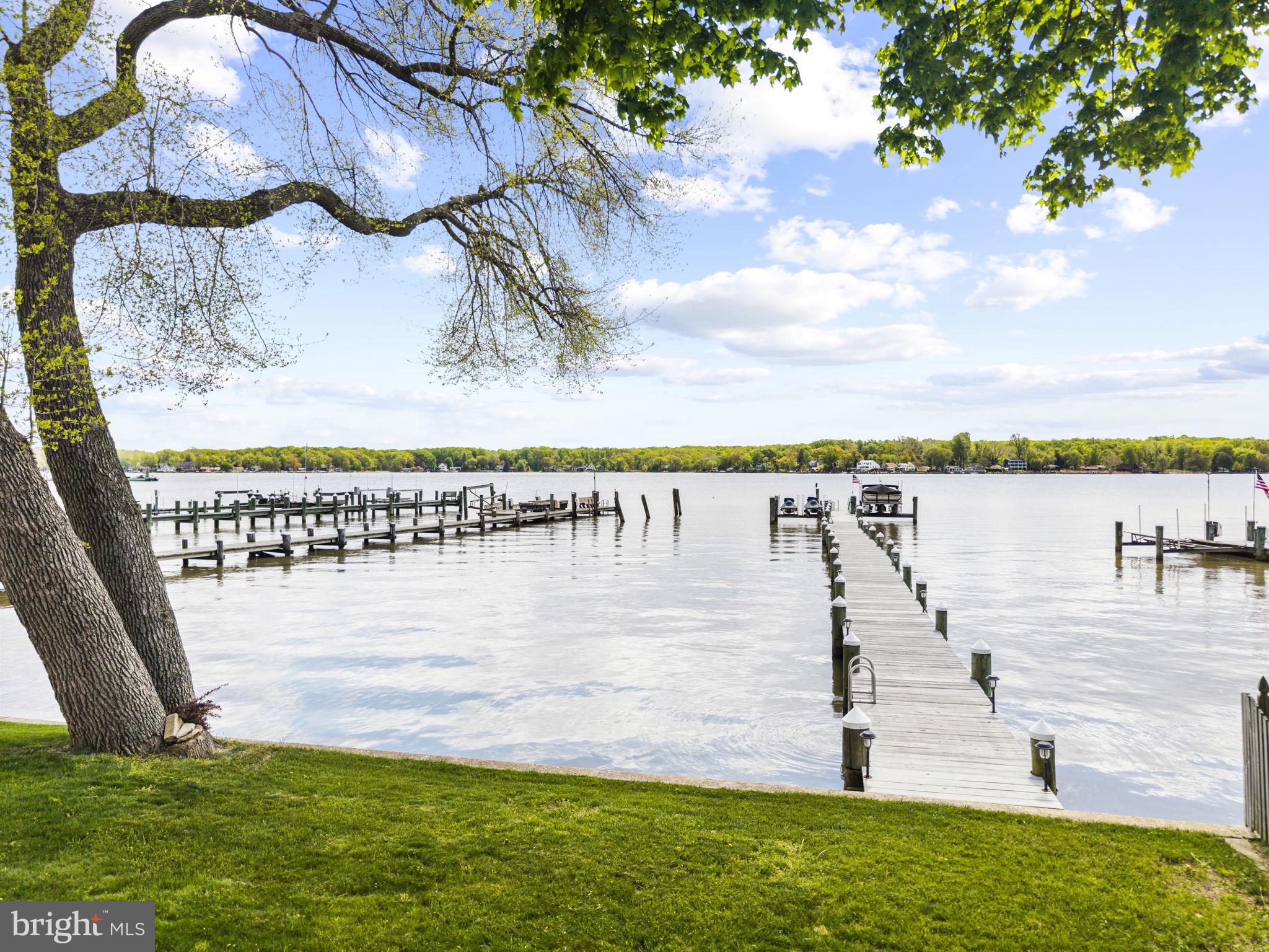 Rare Waterfront Retreat on the Elk River — Private Dock, Stunning Views & Room for Everyone
Welcome to this exceptional waterfront home in Elkton, where breathtaking Elk River views, a private dock with boat lift, and thoughtfully designed living spaces come together to create the ultimate riverfront lifestyle. Classic cedar shake-style siding, a paver walkway, and manicured gardens set the tone from the moment you arrive.
Inside, the dramatic great room impresses with soaring cathedral ceilings, hardwood floors, a granite-surround fireplace, and dual sets of French doors that frame stunning water views. The open floor plan flows into the dining area and a generous kitchen featuring wood cabinetry, a gas range, stainless steel appliances, a large center island with seating, and a built-in wine rack — perfect for entertaining.
The screened porch is the heart of the home — a window-wrapped retreat with panoramic river views and space for a full dining set. An open waterfront deck off the main level offers direct views of the dock and river, ideal for al fresco dining. Upstairs, the expansive primary suite features a private water-view balcony, walk-in closet, and a spa-like bath with freestanding soaking tub, tiled walk-in shower, and built-in vanity. Additional bedrooms include a charming queen guest room and a spacious third-floor bonus bedroom — perfect for family and guests. Upper-level laundry adds everyday convenience.
The oversized two-car garage includes an EV charging outlet, high ceilings, and covered storage underneath the deck for kayaks, paddleboards, and gear. Outside, the lush yard leads directly to your private dock and boat lift — ready for boating, fishing, or simply soaking in the river at golden hour.
This is waterfront living at its finest.