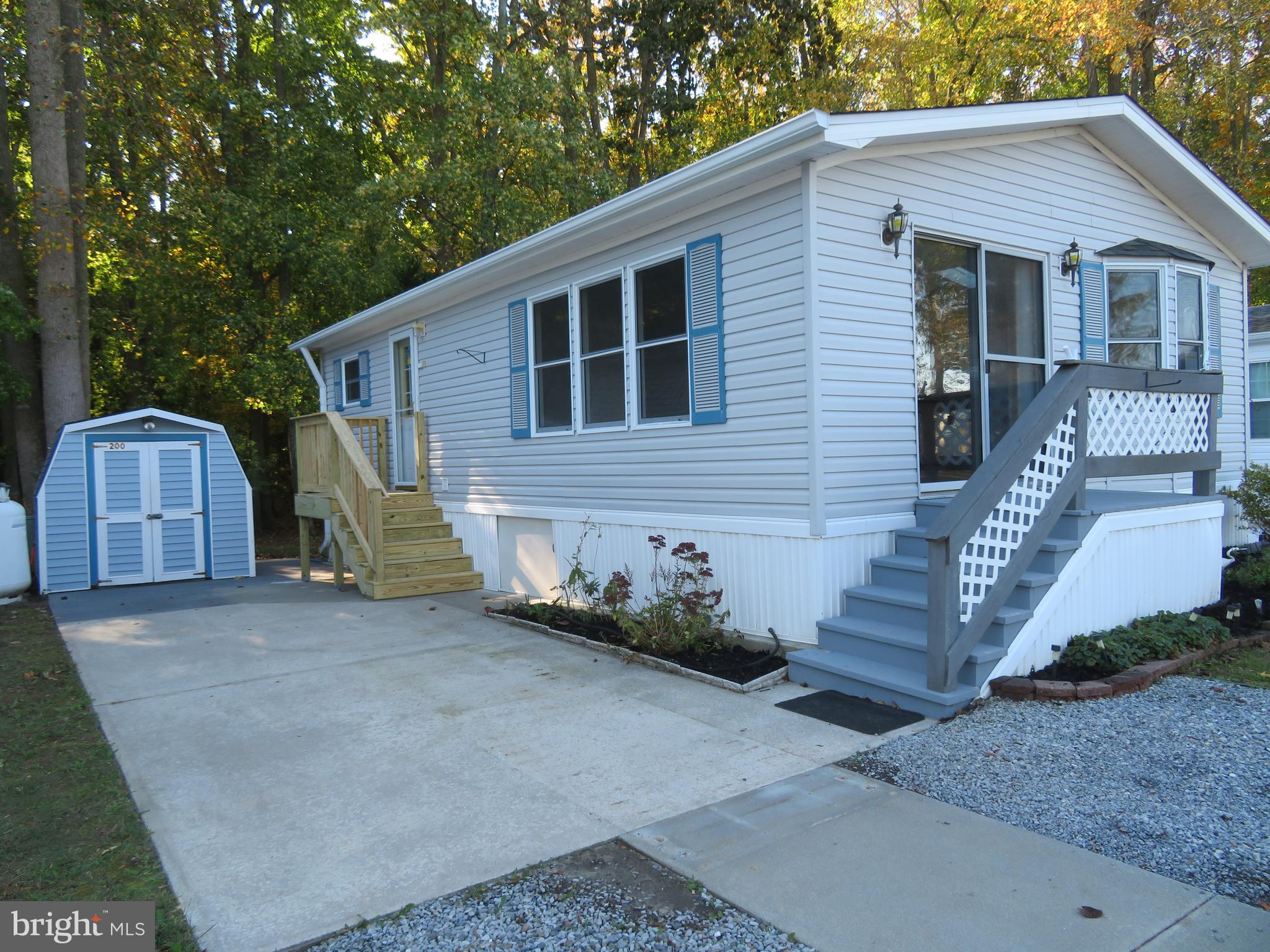 OWN YOUR VACATION SPOT/2nd home on the Eastern Shore approximately 10 minutes to Ocean City beach & boardwalk. OWN LAND & BEACH COTTAGE STYLE HOME. NO GROUND RENT. NOT A RENTAL. Only has had one owner and has been a non smoking  home with no pets. RARE FIND AT THIS PRICE FOR A COTTAGE STYLE HOME. LOTS OF COMMUNITY AMENITIES (Ice cream socials, coffee & donut mornings, bingo, community yard sale, crab feast) & many more.  Location on preferred wooded perimeter of park allows privacy in rear of home , serenity & touch of natures natural beauty  from master bedroom (no homes behind you). 2 bedroom. 465 privately owned homes located in 24 hr. private security/gated ST. MARTINS RIVER waterfront community. Large in ground pool & clubhouse just a stones throw away. Close to 2nd entrance for quicker access. Public water/sewer $49. monthly, cable is $207.89 every 6 months. Included in $116. monthly home owner assoc. fee,  free trash removal,  clubhouse, pool, boat ramp, (small $75. sticker fee for fenced in storage area for boats, boat trailers/jet ski & area to clean your boat). River front marina, piers with boat slips (some slips for daily rentals). Boat slips are $550. for a season. Crabbing gazebo & area to clean your fish . Basketball, tot playground for kids. canoe/kayak racks, picnic tables and grills, 2 bath houses with full showers and bathrooms to rinse the sand off your feet from the beach. 2 laundry rooms. Best of all the park cuts your grass. Freshly painted 10/2023. Gas corner fireplace for those chilly evenings. All appliances included.  Full size washer/dryer, built-in microwave w/splash guard, garbage disposal, gas range and dishwasher. NEW  ROOF & SKYLIGHTS  (2006), HVAC has been replaced (6-27-22), 3 ceiling fans. Brand new LVP flooring Oct. 2023. Recessed lighting and lighting under large breakfast bar & above & below kitchen cabinets. Breakfast bar, kitchen & bath with silestone countertops. Shed has electric. Home also has concrete slab built underneath for additional storage. 2 entrances both front slider and side of home also has storm door w/retractable hide-away screen. Brand new side entrance porch and stairs (Nov 1, 2023. Home is sold unfurnished. Overflow parking for extra guest just doors away. Hop, skip & jump to many restaurants, shops & casino. Across street from park has walkway to weekly farmers market, craft shows & bands under a pavilion, large playground during some seasons. SOLD AS IS- owner does not know of any latent defects in the home except water & ice dispenser never used.  Home in good shape and needs very little TLC to make it your own. This is an excellent price for a cottage style home.  Please note there are some limited restrictions as to when you can stay in park during winter months. There is off season occupancy use per county code. Full time use April 1-September 30th. 60 days total use from October 1-March 31 with a 30 consecutive day max. Ask listing agent or park manager.  Park is open 365 days. Must enter park w/REALTOR by signing in at either office or security gate. Office is open 8am to 4pm except closed on Sunday. When office is closed security guard is at gatehouse in front of office.