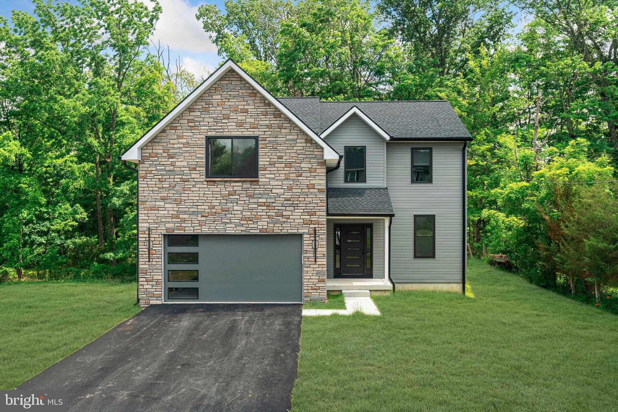 Nestled in a picturesque setting overlooking preserved open space and a gently flowing stream, this exceptional custom built home offers the perfect blend of luxury, comfort, and everyday practicality.

From the moment you step inside, you'll appreciate the bright, open design and quality craftsmanship showcased throughout. Rich engineered hardwood flooring spans the main level, complemented by spacious living areas designed to accommodate both relaxed daily living and effortless entertaining.

At the center of the home is a beautifully appointed kitchen that combines style and functionality. Featuring brand new white and light gray maple shaker cabinetry, granite countertops, abundant storage, stainless steel appliances, and a generous breakfast area, this space is perfectly suited for everything from morning coffee to hosting family and friends.

Just beyond the breakfast area, sliding doors lead to a private deck where you can enjoy outdoor dining, summer gatherings, or simply take in the peaceful views of the surrounding natural landscape.

Practical features have been thoughtfully incorporated throughout, including a mudroom with coat closet conveniently located off the attached two car garage. The home also offers two zone heating and cooling for enhanced comfort and efficiency, along with prewiring for security cameras.

The second level features four spacious bedrooms, two full bathrooms, and a conveniently located laundry room. The well designed layout provides ample space for family members and guests while maintaining privacy and functionality.

Adding even more value is the expansive unfinished basement, complete with a finished powder room and endless possibilities for future customization. Whether you envision a home theater, fitness studio, game room, additional living area, or private retreat, the space is ready to accommodate your needs.

Offering high quality custom construction, thoughtful design, premium finishes, and a tranquil Bucks County location, this remarkable home presents a rare opportunity to enjoy the benefits of new construction in one of Central Bucks County's most sought after communities.