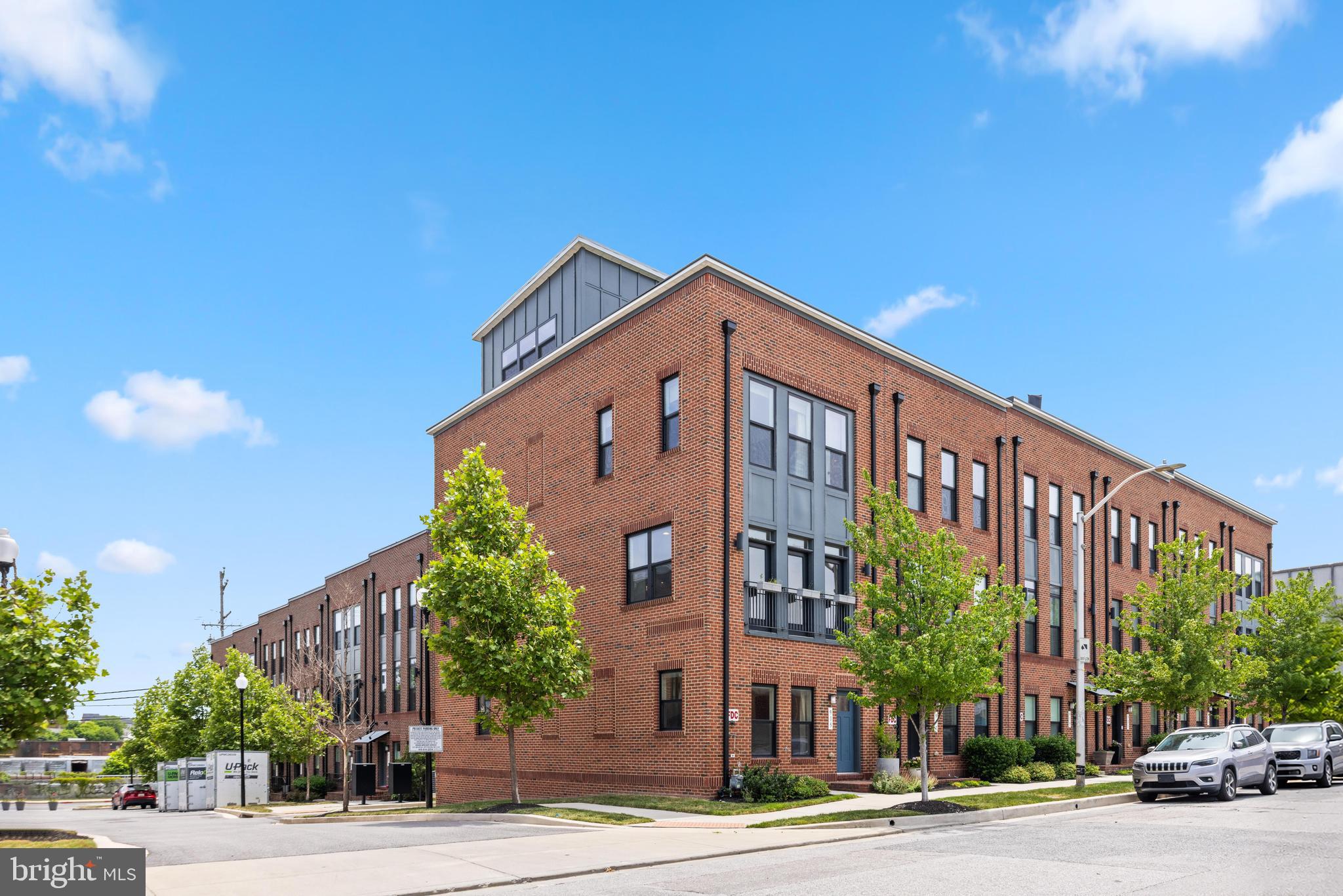 OPEN HOUSE SAT JUNE 27th 11-1! Built 7 years ago, this is an exceptional home that combines space, convenience, and city living in one unforgettable package. This stunning all-brick end-unit townhome offers over 2,600 square feet across 4 finished levels above grade and an oversized rear entry attached garage for 2 cars. Located in one of Baltimore’s most sought-after neighborhoods [Brewer's Hill]. Let's me take you on a visual tour - as you enter the front of the home. you'll find a main level bedroom and full bathroom - this could serve as a home office or 4th bedroom based on your needs. Take the steps up to the "main level" - this open concept space is designed designed for both everyday living and entertaining, featuring soaring ceilings, luxury vinyl plank flooring, custom lighting, quartz countertops, stainless steel appliances, and an oversized center island that anchors the space. The living room is centered by a fireplace and massive windows flooding the space with nature light, there's even a small balcony off living room for some fresh air. The dining area off the kitchen has the space for full size, proper dining room table - yes you can invite the entire extended family over for Thanksgiving here. Moving up to 3rd level where you'll find 3 bedrooms, 2 full bathrooms + laundry closet.  Retreat to the primary suite, complete with a custom built in walk-in closet and an ensuite bath featuring dual vanities and a frameless waterfall shower. Continue up to the show-stopping 4th level loft - perfect for relaxing, entertaining, or taking in city views. Use this space for however you envision it - super convenient half bath, built-in workspace, mini fridge, projector for movie nights, and access to two expansive rooftop terraces on both sides. This home has been tastefully painted prior to listing to calming, neutral tones throughout. Don't miss your opportunity to own one of Brewer's Hill's finest homes! Ideally located just minutes from I-95, Johns Hopkins, and the University of Maryland Medical Center, you'll enjoy easy access to major employers, dining, shopping, and entertainment. Note: Johns Hopkins employees may qualify for the "Live Near Your Work" $5000 grant program towards closing costs.